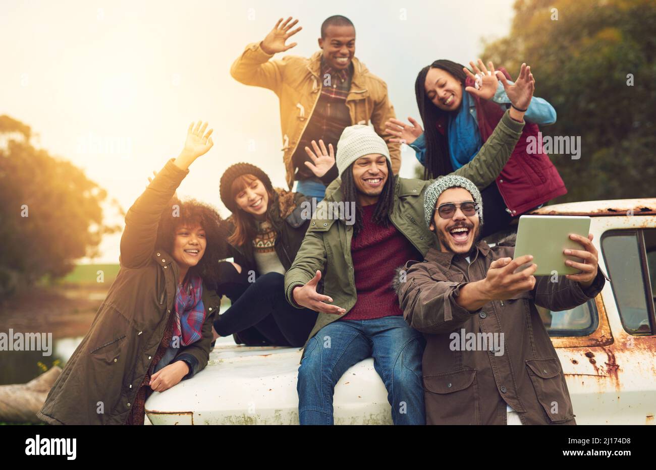 Ciao social media, Ciao mondo. Scatto di un gruppo di amici in posa per un selfie mentre si diverte all'aperto. Foto Stock