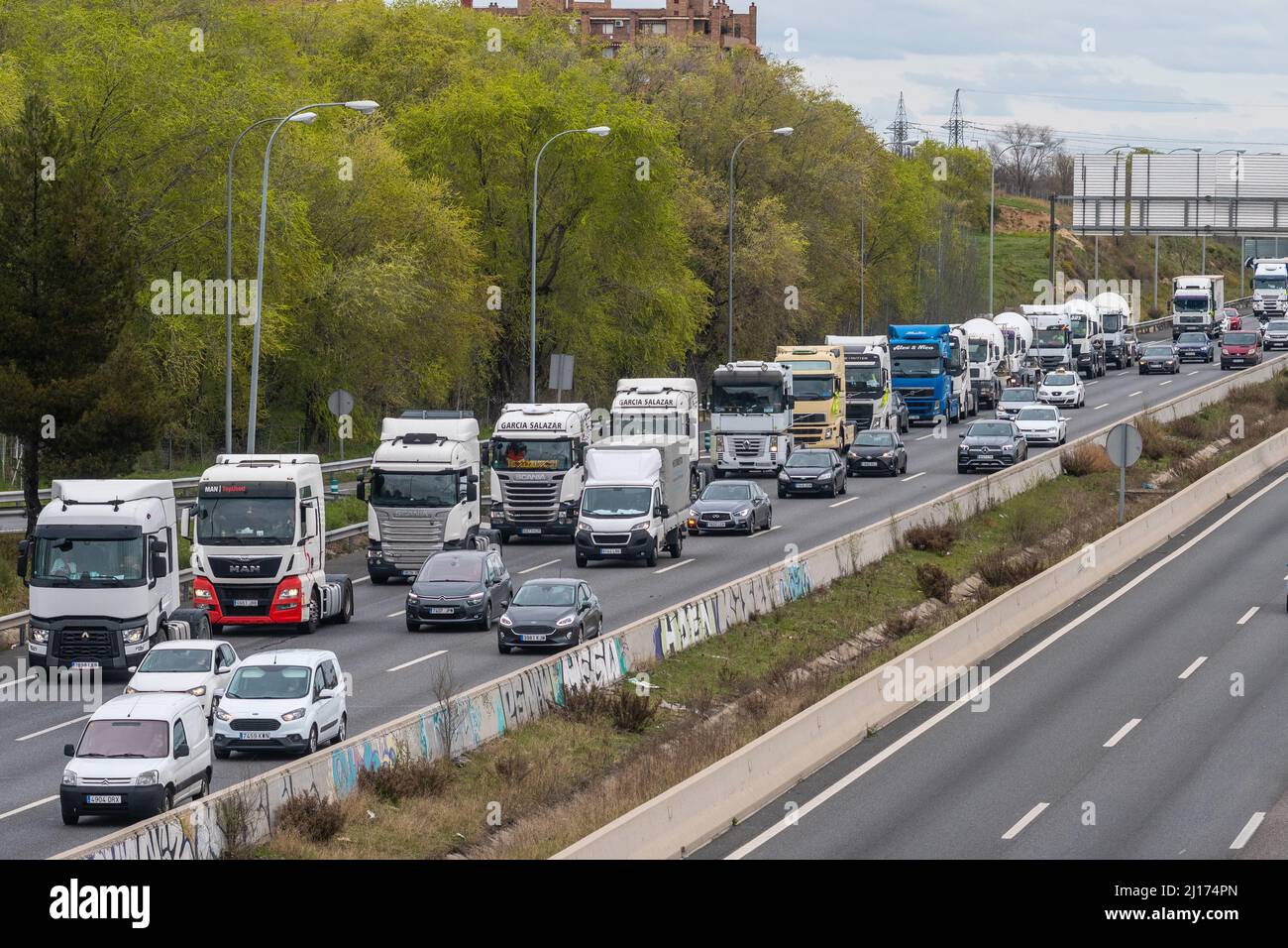 Madrid, Spagna. 23rd Mar 2022. I camion sono visti fare una marcia lenta nell'autostrada M-40 durante il decimo giorno di uno sciopero nazionale di trasporto. I conducenti di autocarri protestano contro le loro precarie condizioni di lavoro e contro l'aumento dei prezzi dei carburanti, accentuato dall'invasione russa dell'Ucraina. I camionisti si sono riuniti con più di 600 camion e betoniere e manterranno uno sciopero indefinito fino al raggiungimento di un accordo con il governo. Credit: Marcos del Maio/Alamy Live News Foto Stock