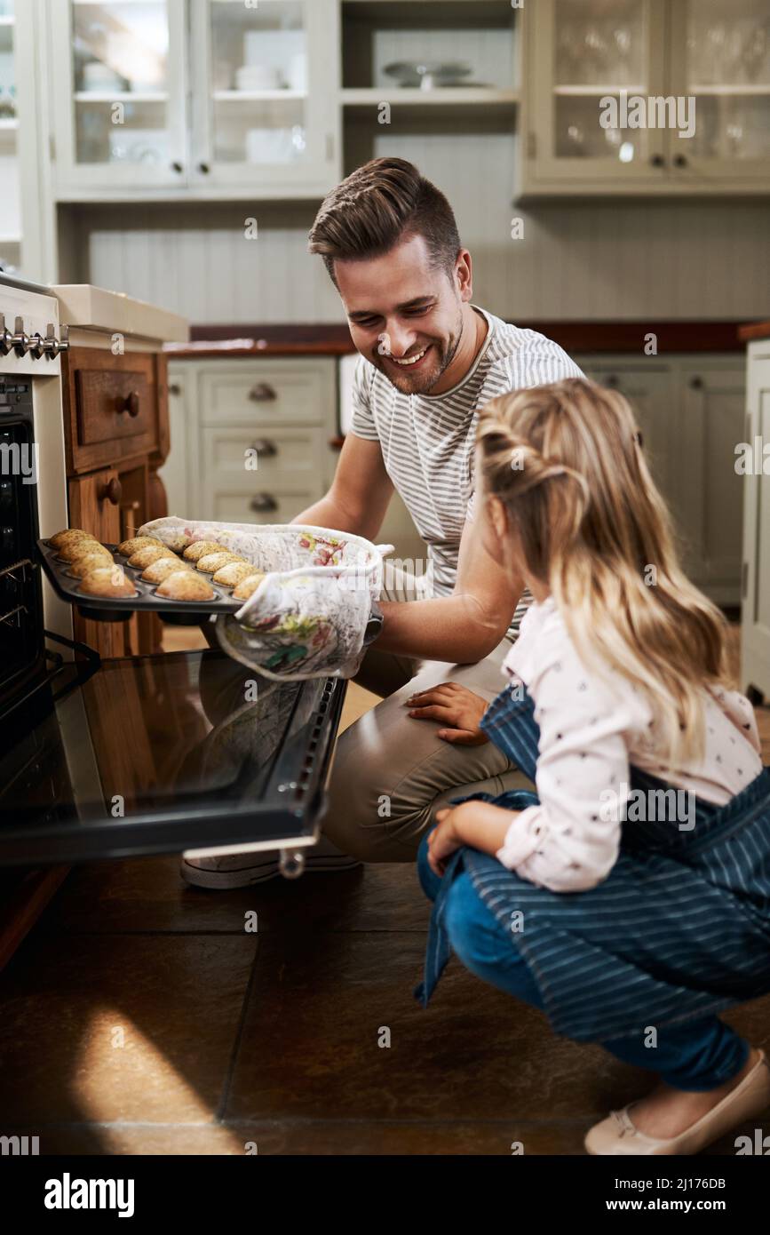 I muffin sono stati perfetti. Scatto corto di una ragazza giovane e suo padre che cuoce a casa. Foto Stock