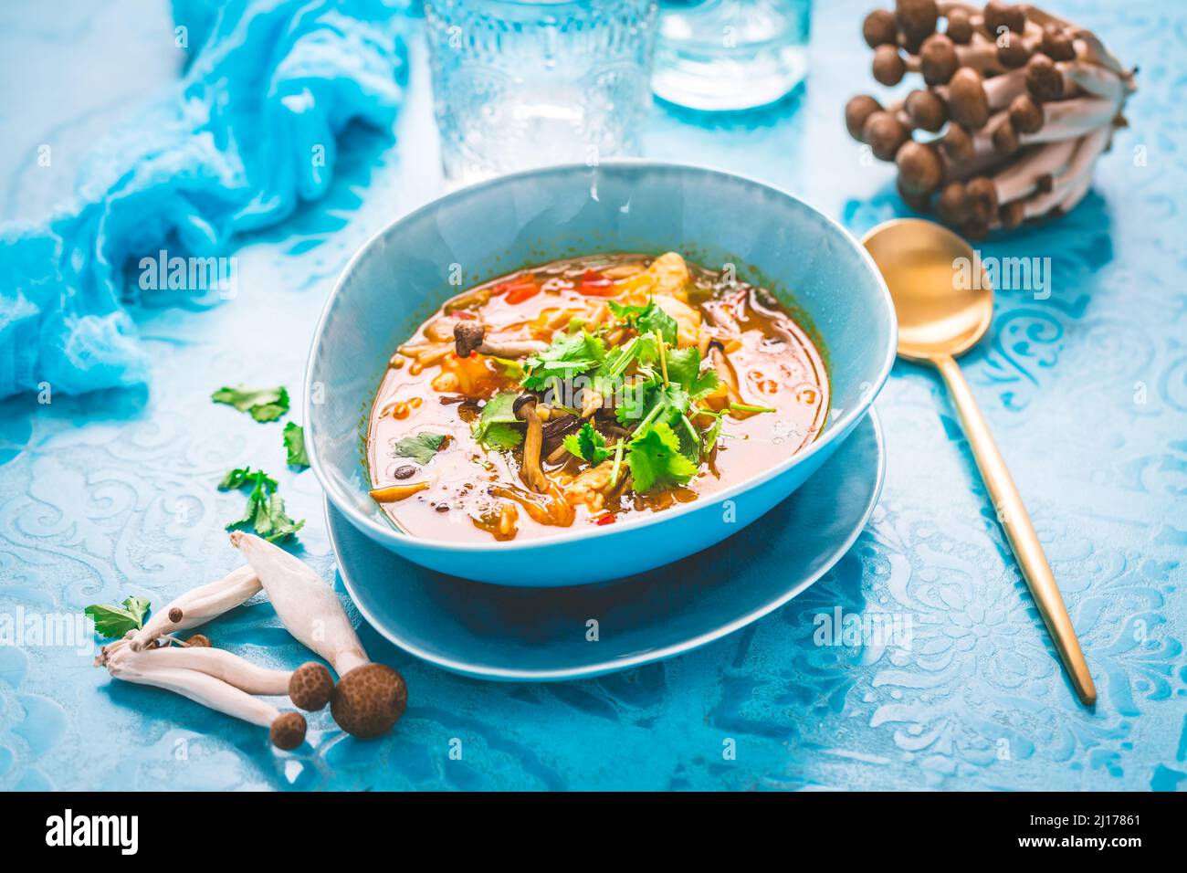 Curry rosso di pollo tailandese. Thailandia tradizione rosso curry zuppa con pollo, funghi e latte di cocco su sfondo blu Foto Stock