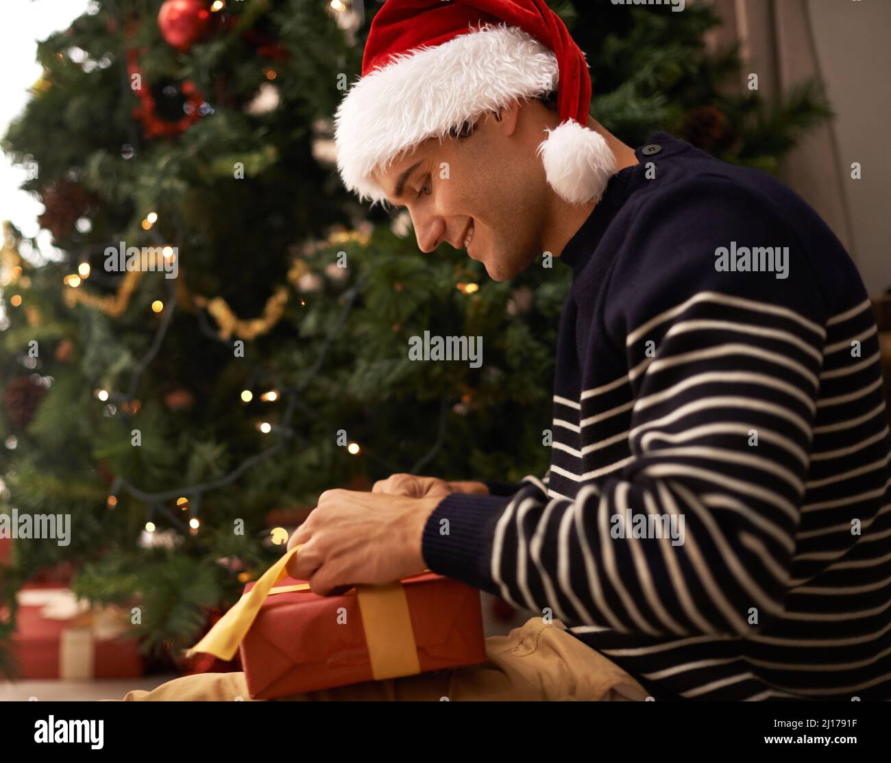 Diffondere lo spirito di Natale. Scatto di un bel giovane uomo che si prepara per Natale. Foto Stock