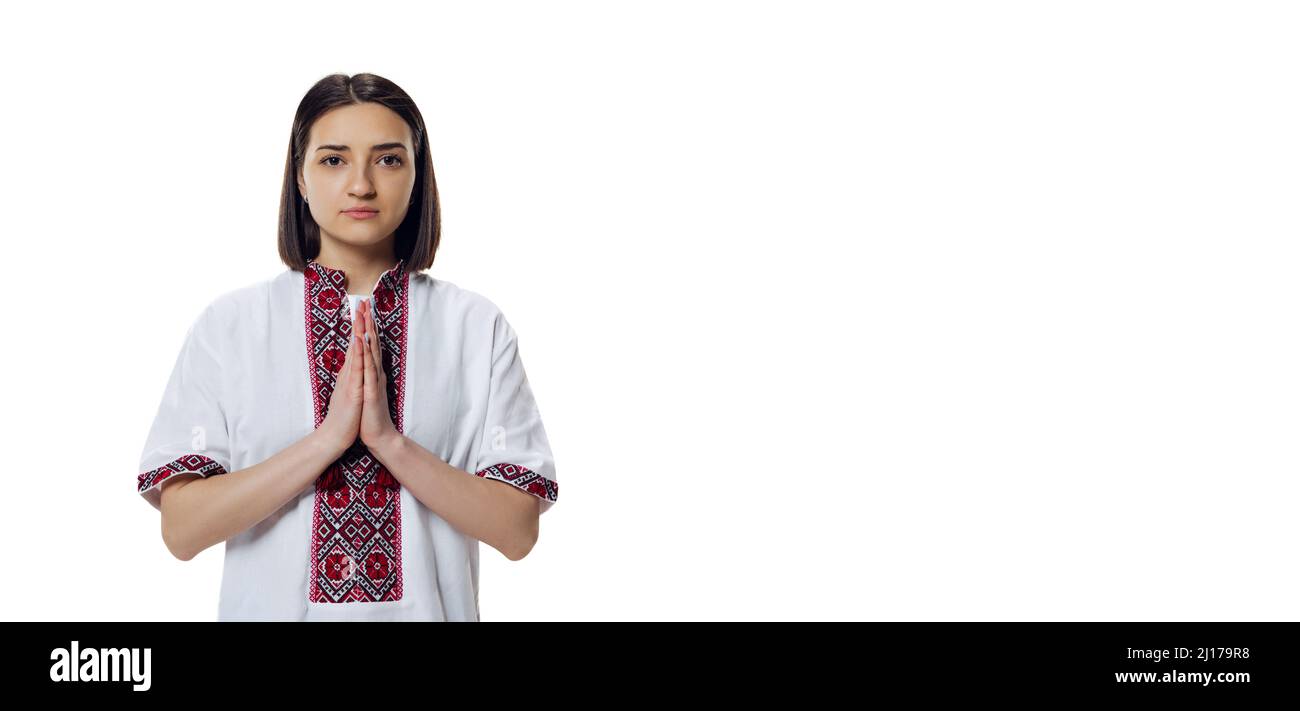 Ritratto di bella donna in stoffa tradizionale ucraina - camicia da ricamo, vyshyvanka che prega isolato su sfondo bianco studio. Foto Stock