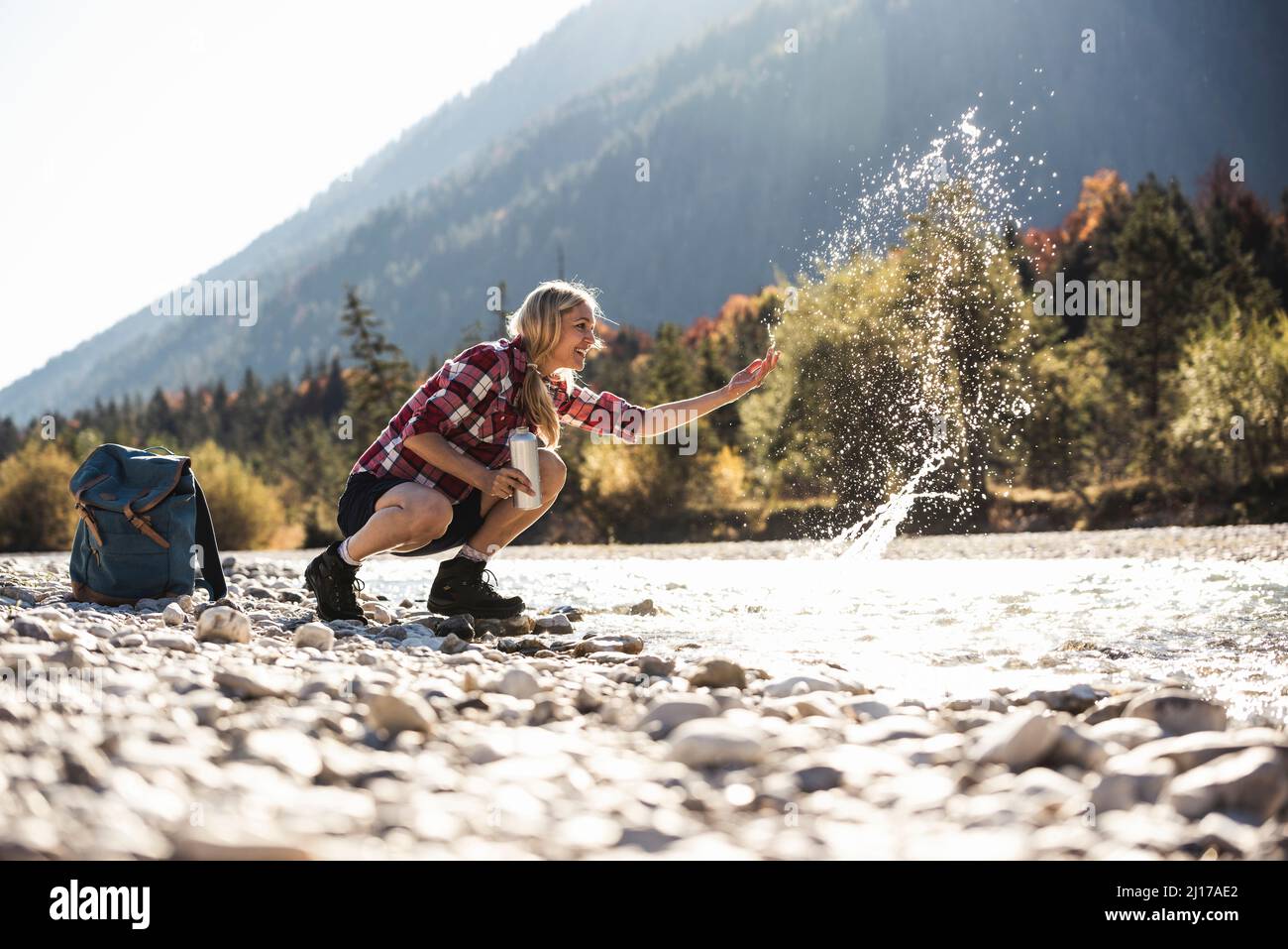 Austria, Alpi, donna su una escursione con spruzzi di acqua in un ruscello Foto Stock