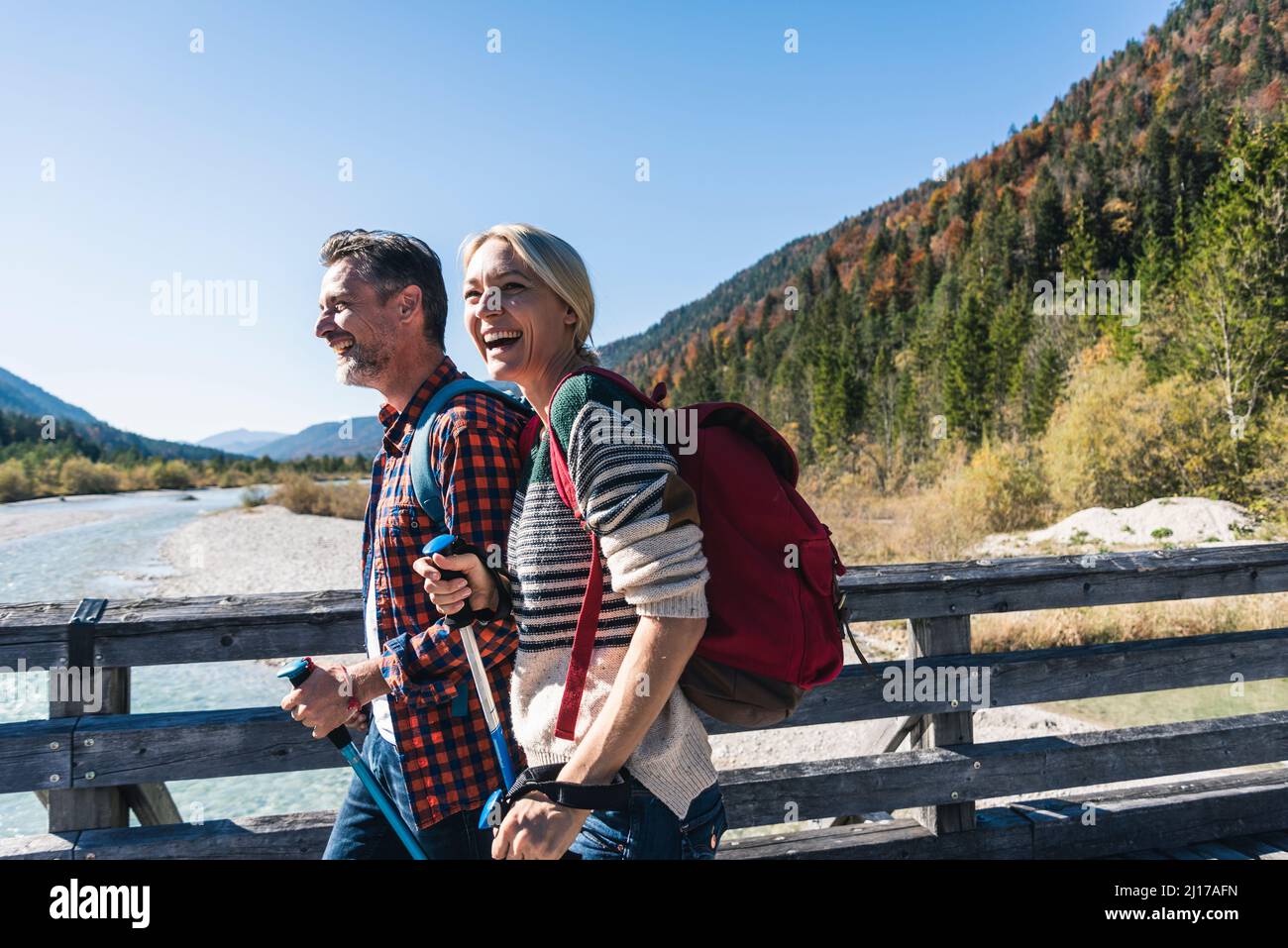 Austria, Alpi coppia felice su una escursione attraversando un ponte Foto Stock