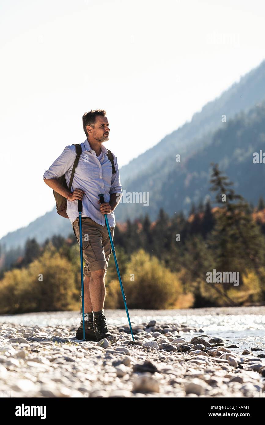 Austria, Alpi, uomo su una escursione in piedi su ciottoli in corrispondenza di un ruscello Foto Stock