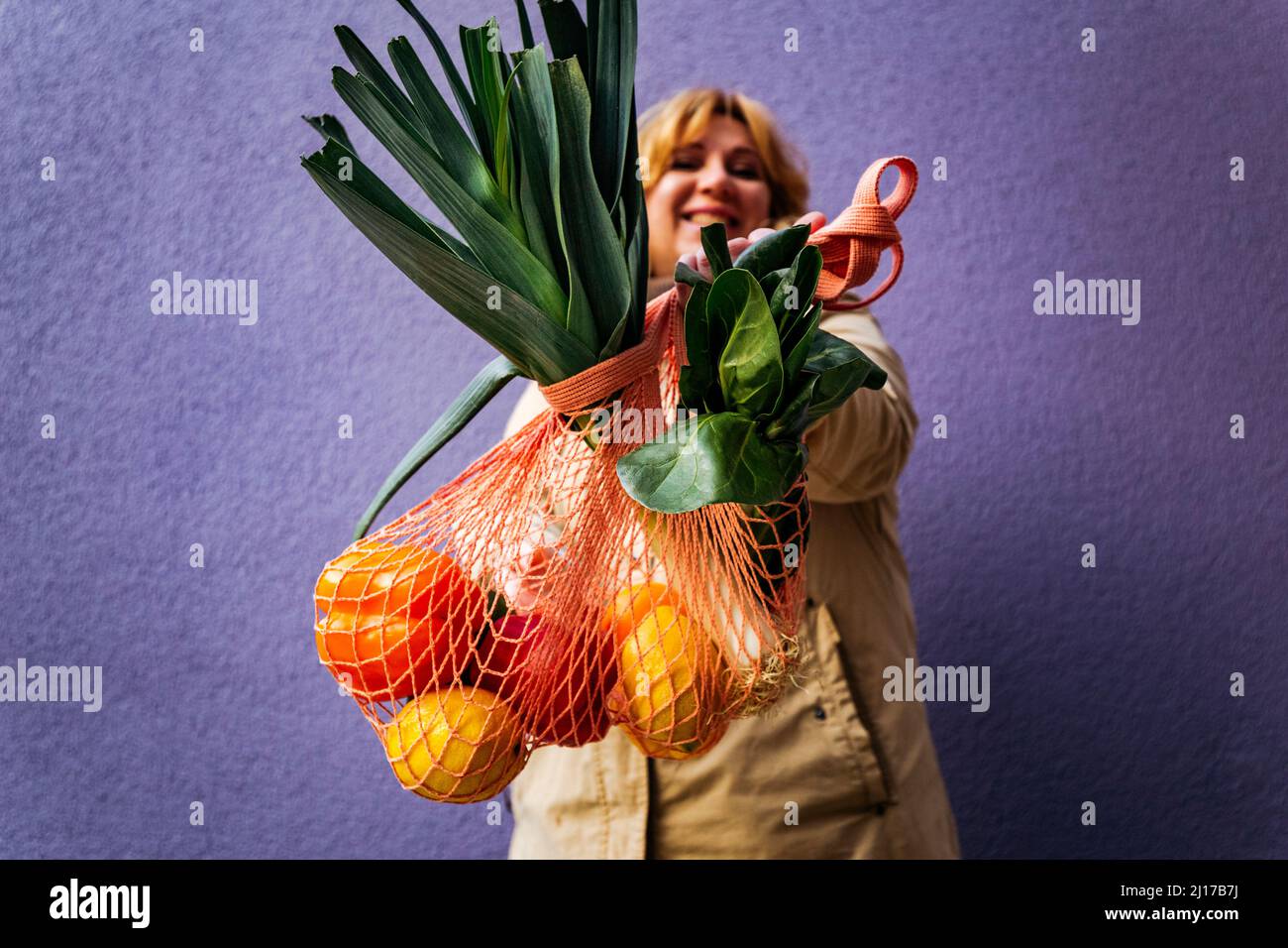 Donna che mostra un sacchetto riutilizzabile di verdure Foto Stock