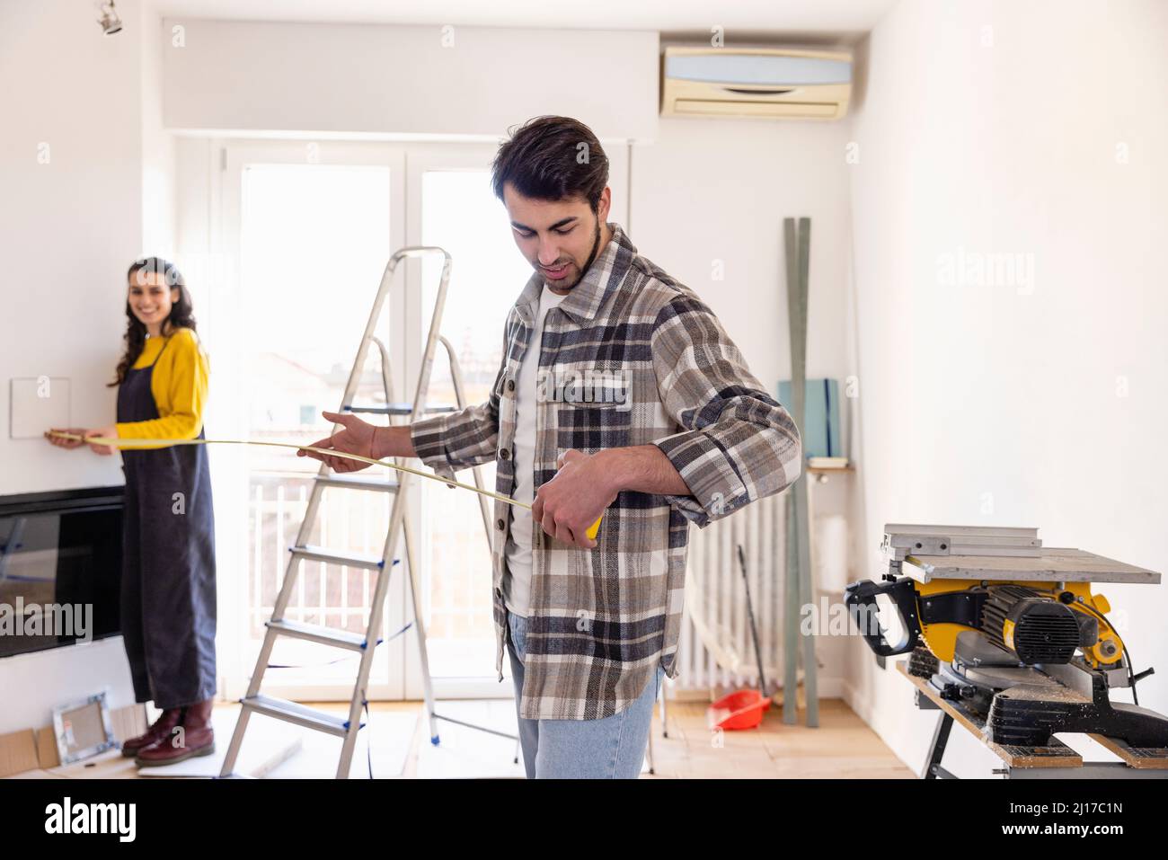 Camera di misura per le coppie giovani a casa lavori di ristrutturazione Foto Stock