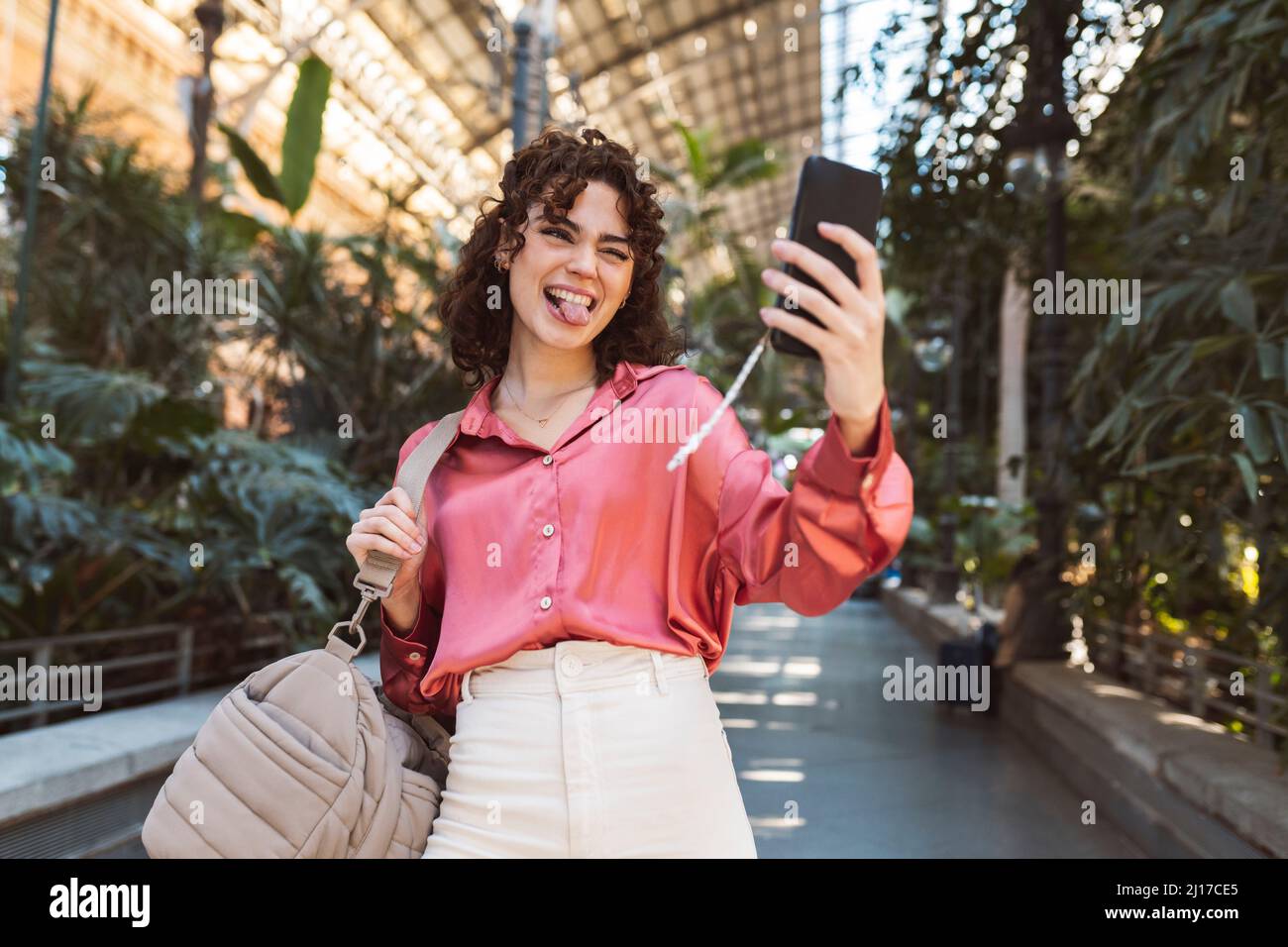 Donna che attacca la lingua e prende selfie sullo smartphone Foto Stock