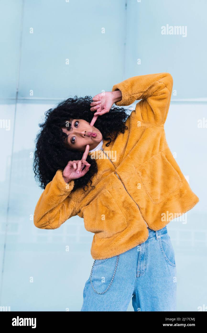 Donna che fa il pesce faccia grimace di fronte al muro Foto Stock