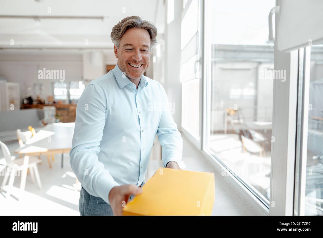 Felice uomo d'affari che riceve la scatola in ufficio Foto Stock