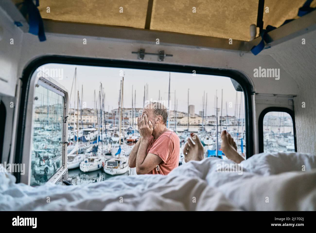 Uomo che ricopre il viso con le mani da camper Foto Stock