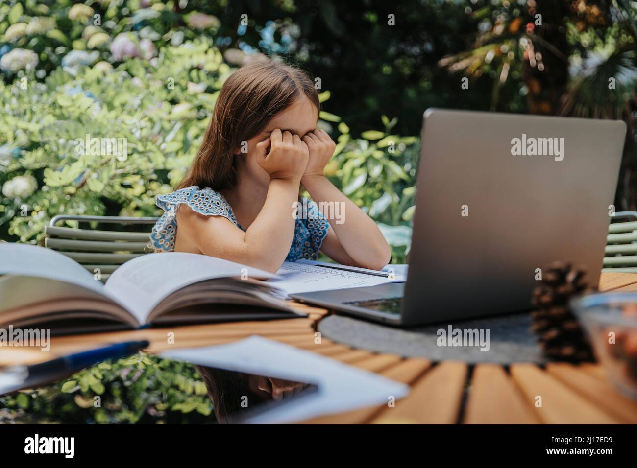 Ragazza sopraffatta con il laptop all'istruzione in linea Foto Stock