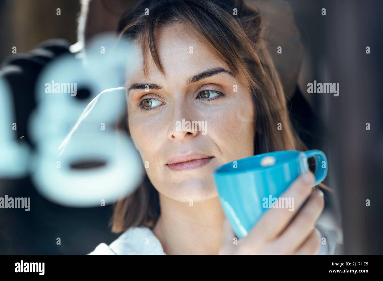 Donna premurosa con tazza da tè blu Foto Stock