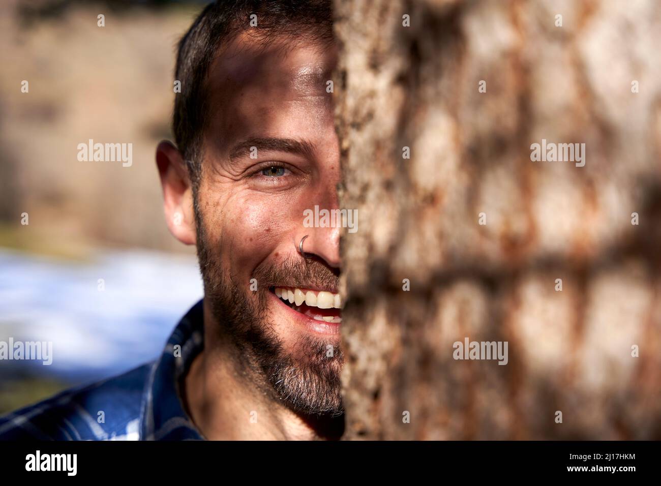 L'uomo felice dietro il camion dell'albero in giorno di sole Foto Stock