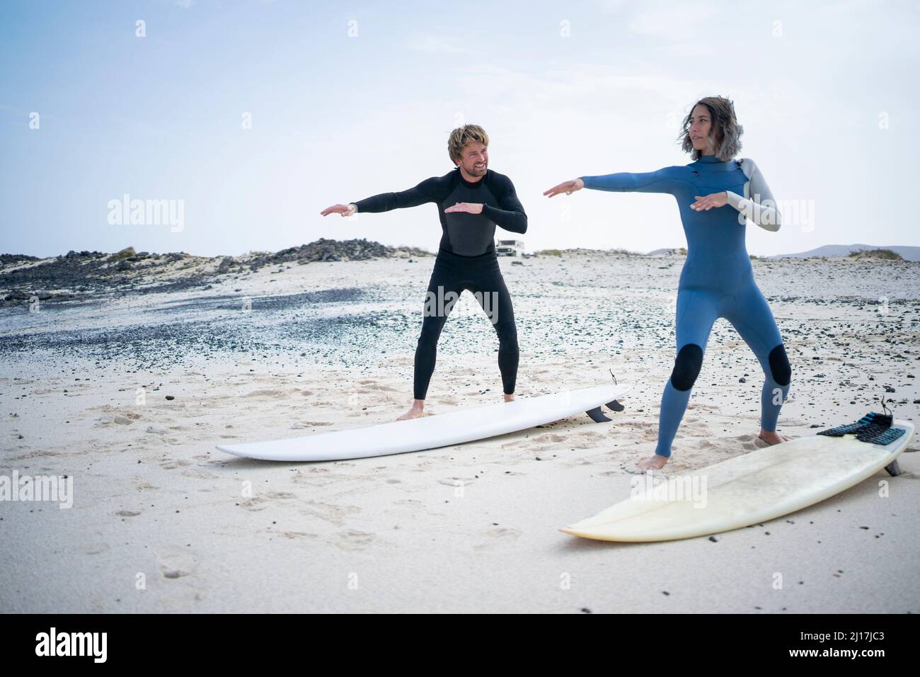 Uomo insegnamento donna surf lezione sulla spiaggia Foto Stock