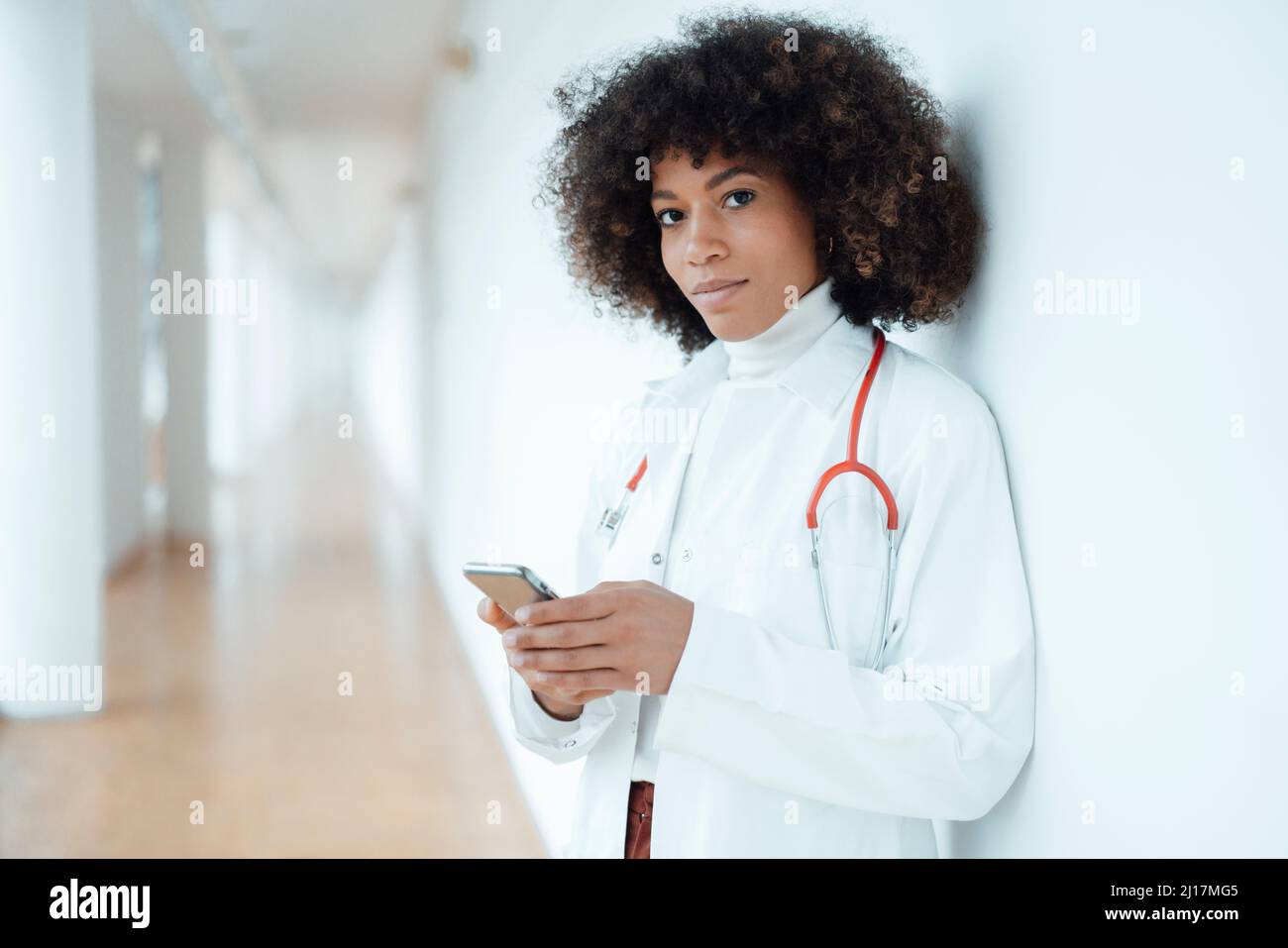 Medico con telefono cellulare in clinica medica Foto Stock