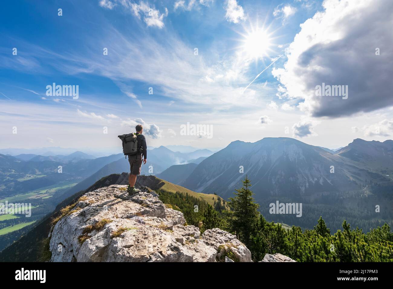 Escursionista maschile ammirando la vista dalla cima del monte Aiplspitz Foto Stock