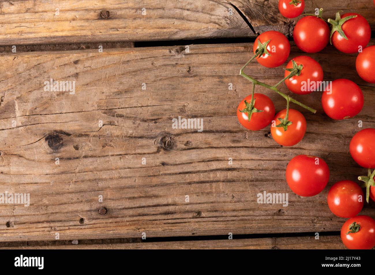 Direttamente sopra la vista dei pomodori freschi di ciliegia rossa su un tavolo di legno marrone Foto Stock