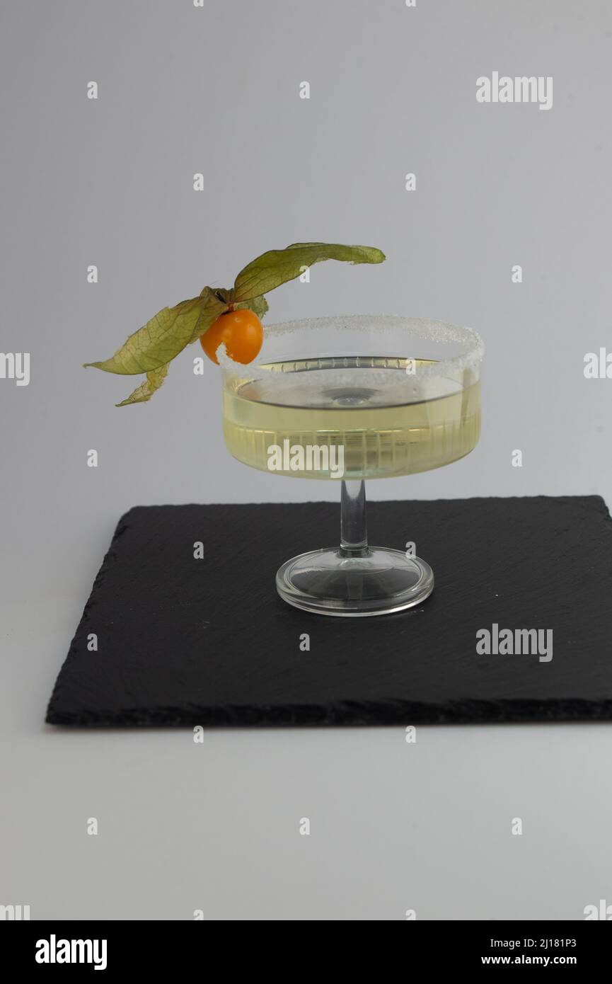 Un primo piano di un gimlet cocktail Lime sciroppo gin zucchero bordo fruttato isolato su sfondo grigio Foto Stock