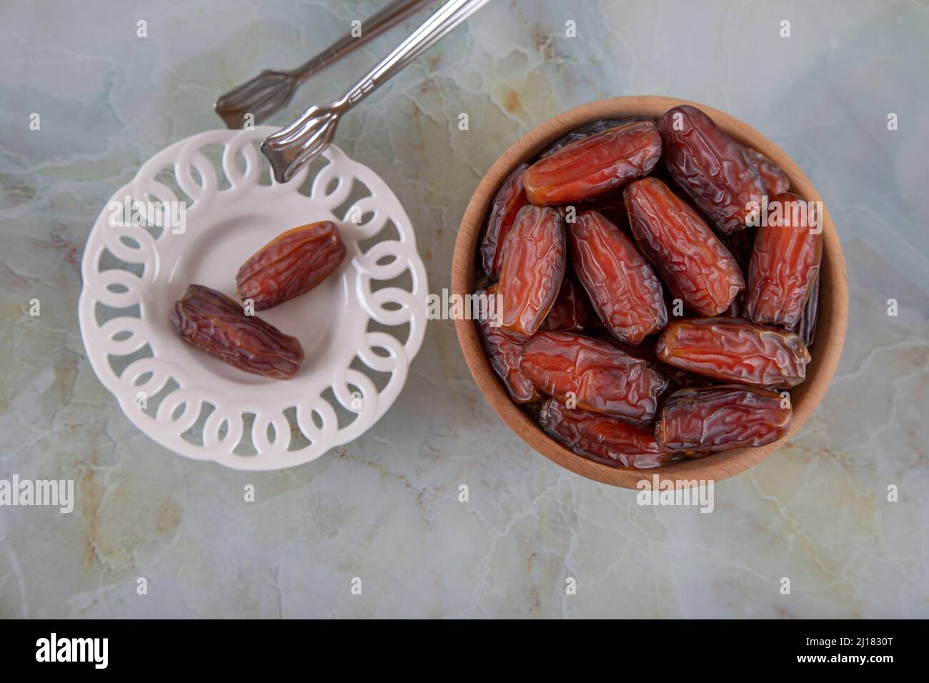 Date frutta in due ciotole su sfondo marmo colorato, vista dall'alto Foto Stock
