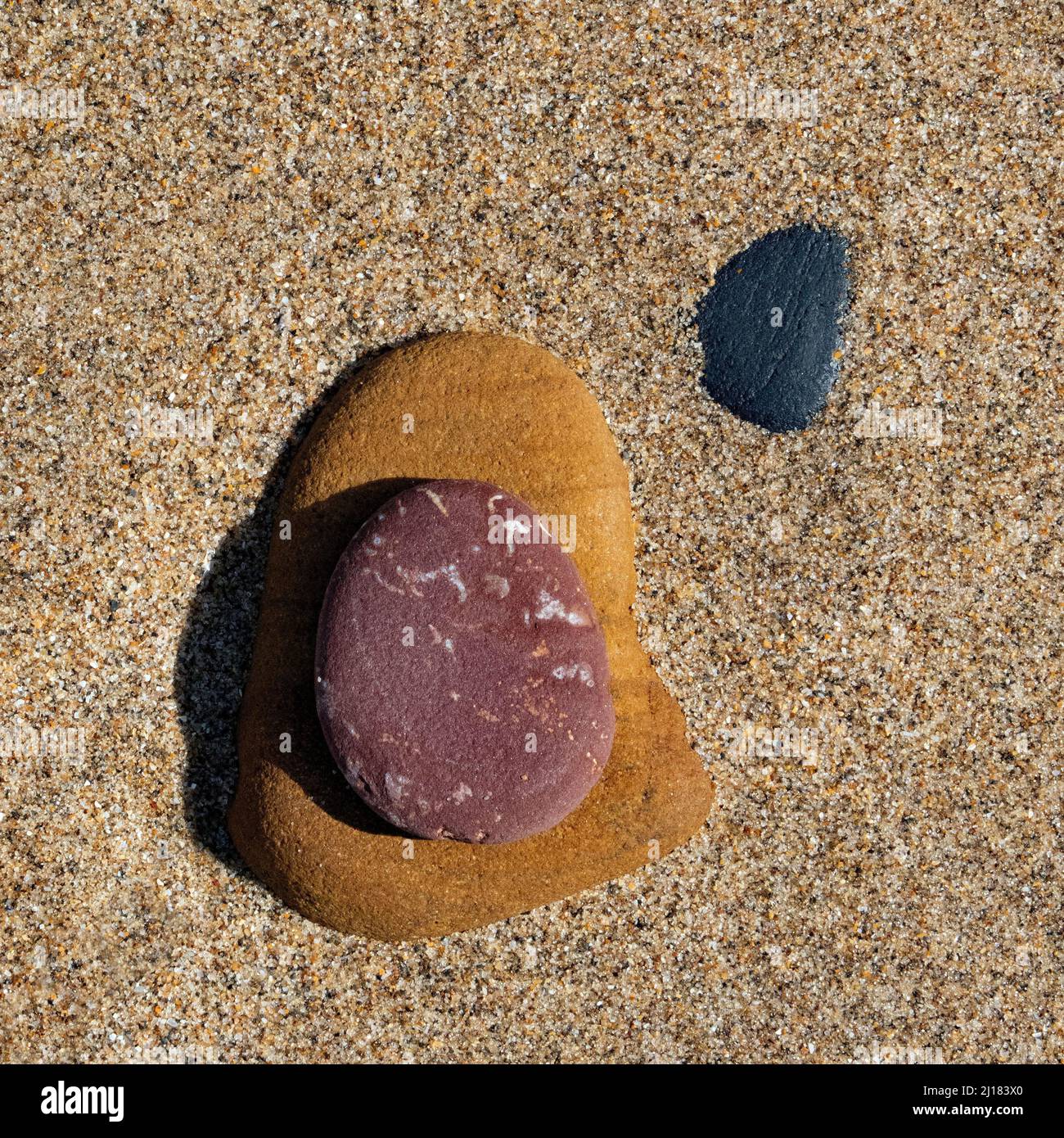 Foto a colori di pietre costiere sulla spiaggia levigata e arrotondata dai passaggi del tempo e marea contenente ciottoli di pietra e ciottoli con grana p Foto Stock