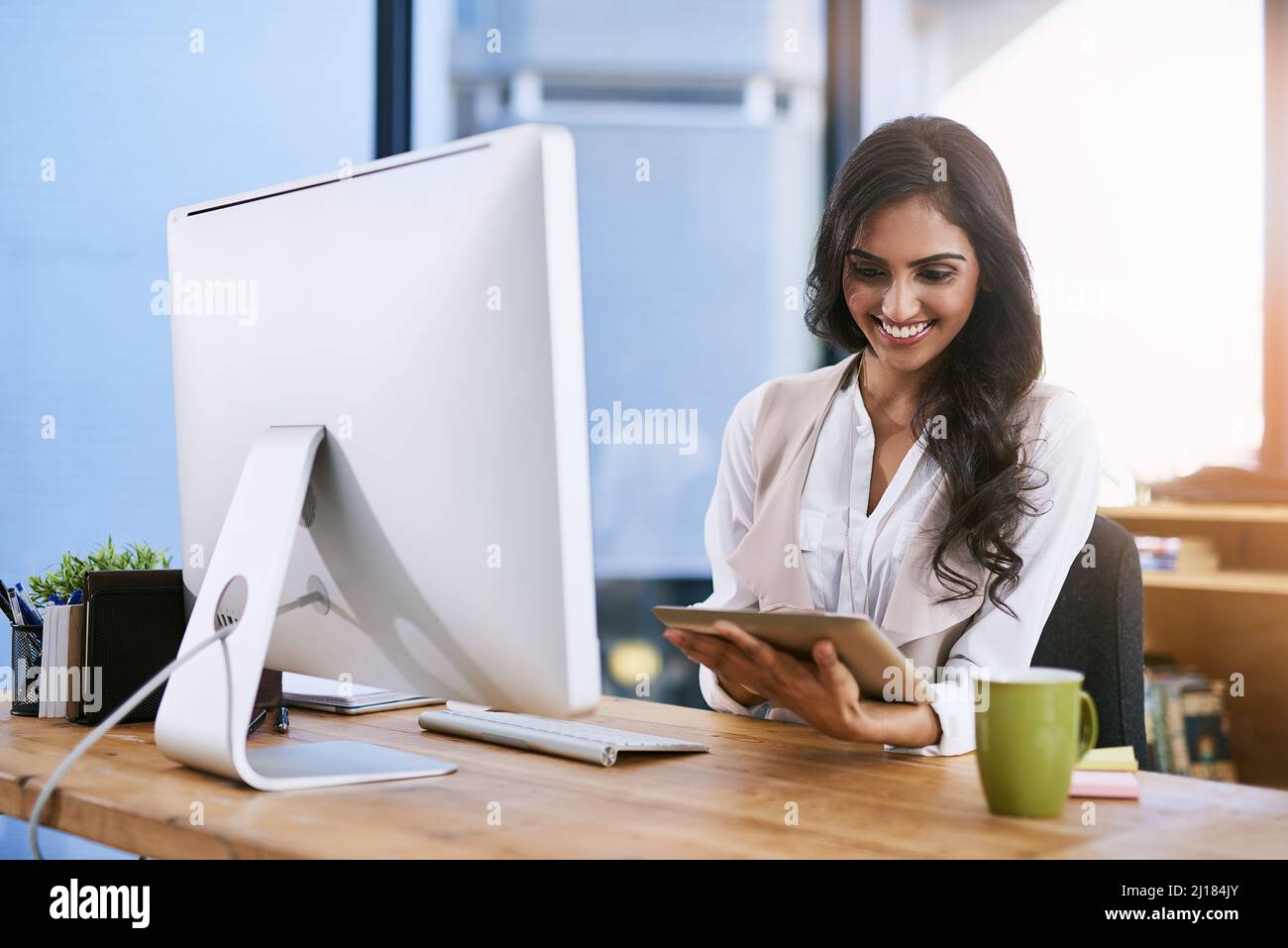 La passione è la scintilla che illumina il vostro cammino verso il successo. Scatto di una donna d'affari che usa il suo tablet digitale mentre si siede alla sua scrivania. Foto Stock