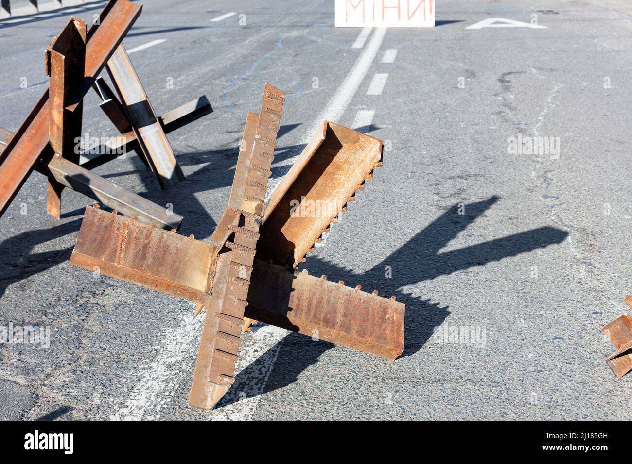 Guerra della Russia contro l'Ucraina. Strutture metalliche anticarro sulle strade di Kyiv. Riccio antitank sulla carreggiata di una strada cittadina in una giornata di sole. Foto Stock
