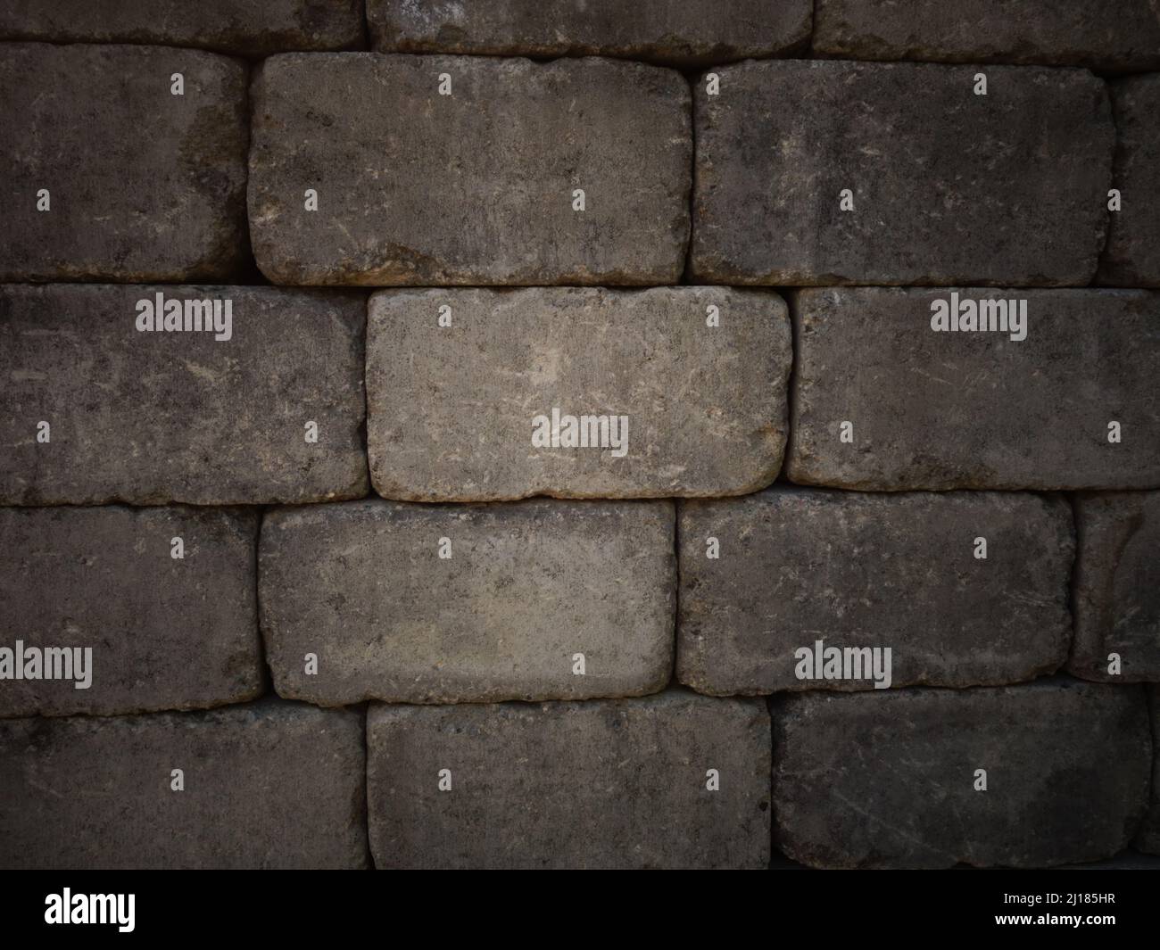 Parete di mattoni di pietra grigia adatta come sfondo per il testo per creare o progettare un poster, una scheda, un disegno o sfondo di pagina web con un aspetto classico e rustico. Foto Stock