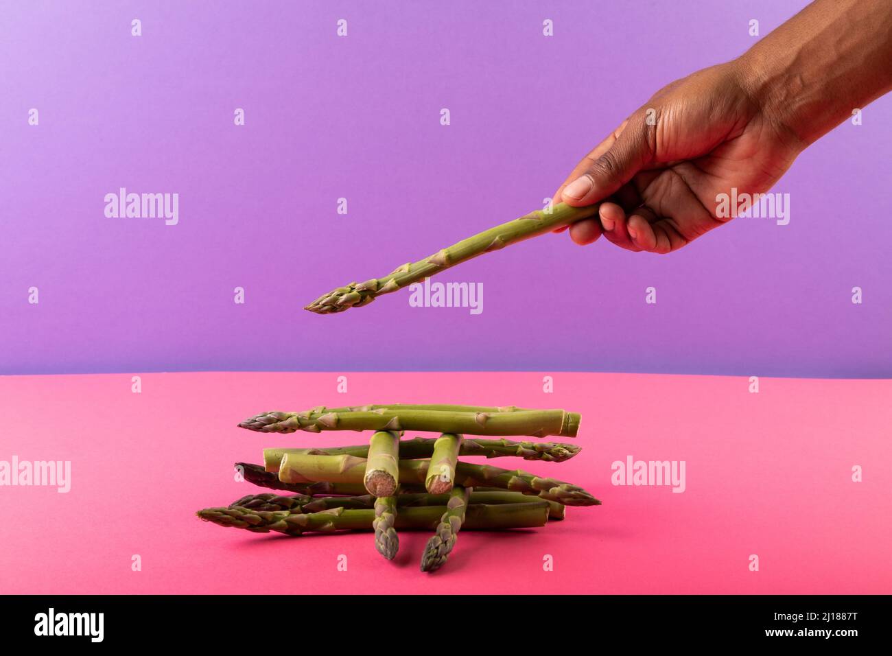 Asparagi tagliati a mano su sfondo a due toni con spazio di copia Foto Stock