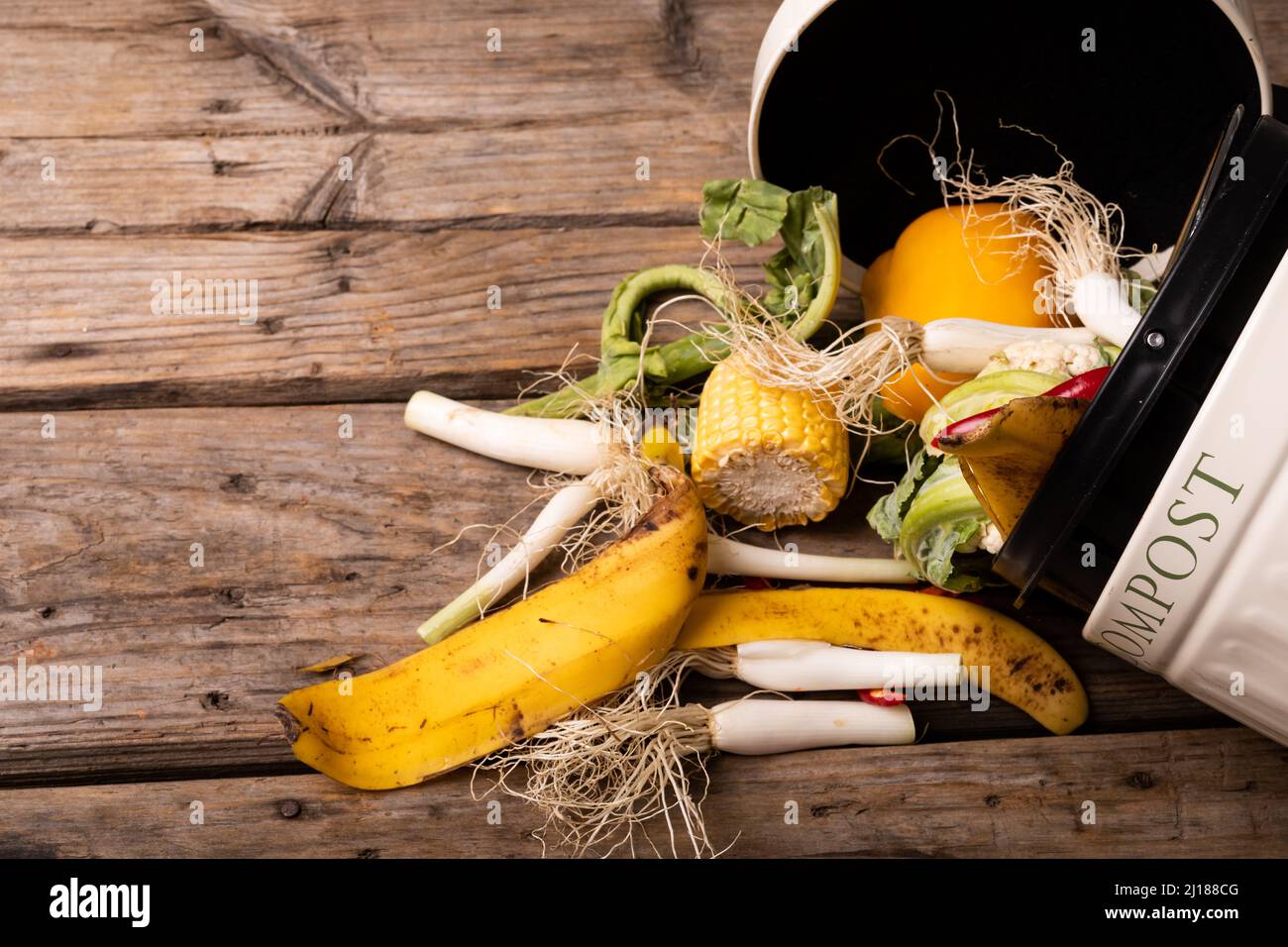 Vista dall'alto dei rifiuti organici fuoriusciti in un contenitore di compost su un tavolo di legno Foto Stock