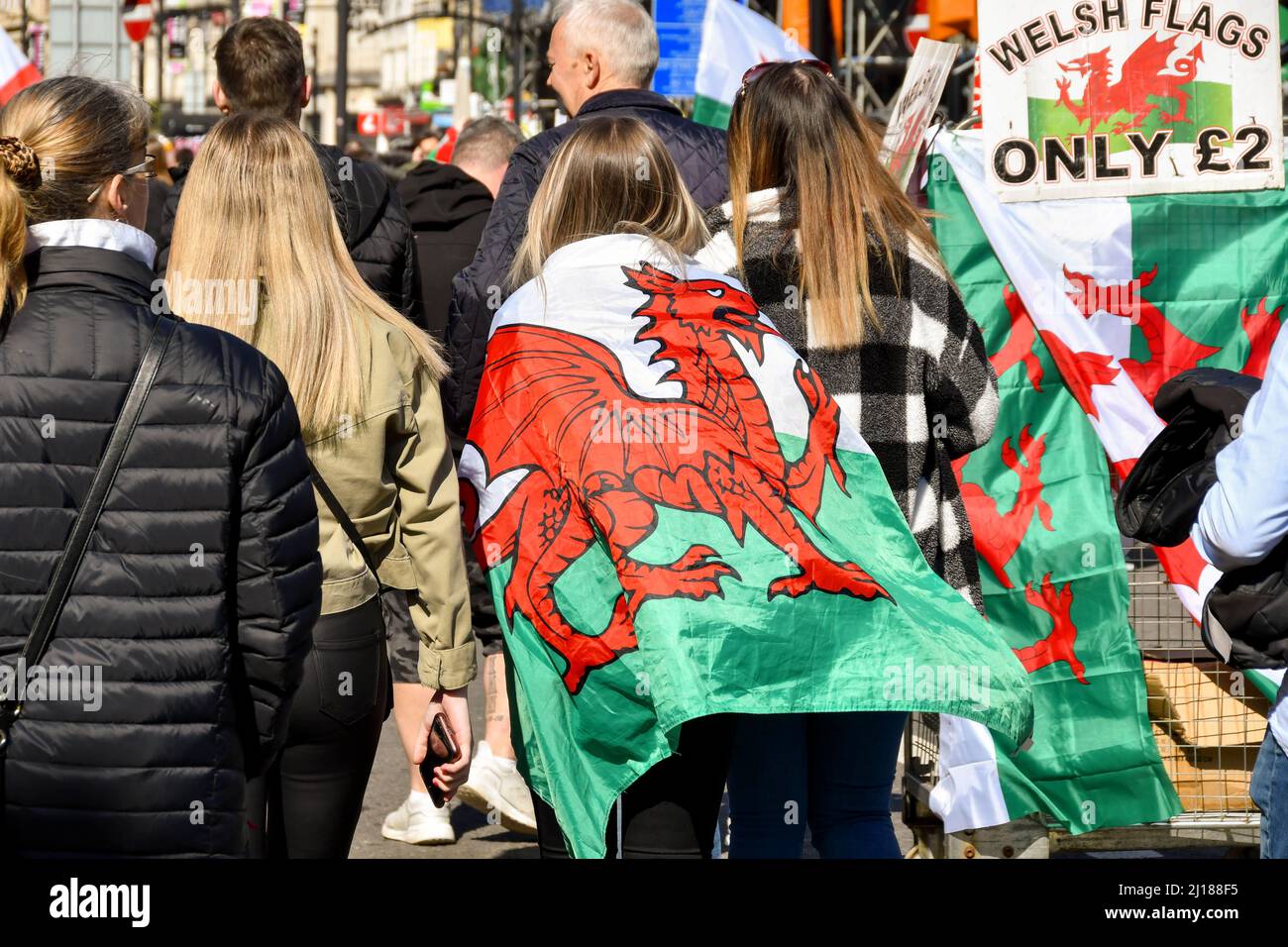 Cardiff, Galles - 2022 marzo: Tifoso di rugby con una bandiera gallese intorno alle sue spalle nel centreflag della città di Cardiff Foto Stock