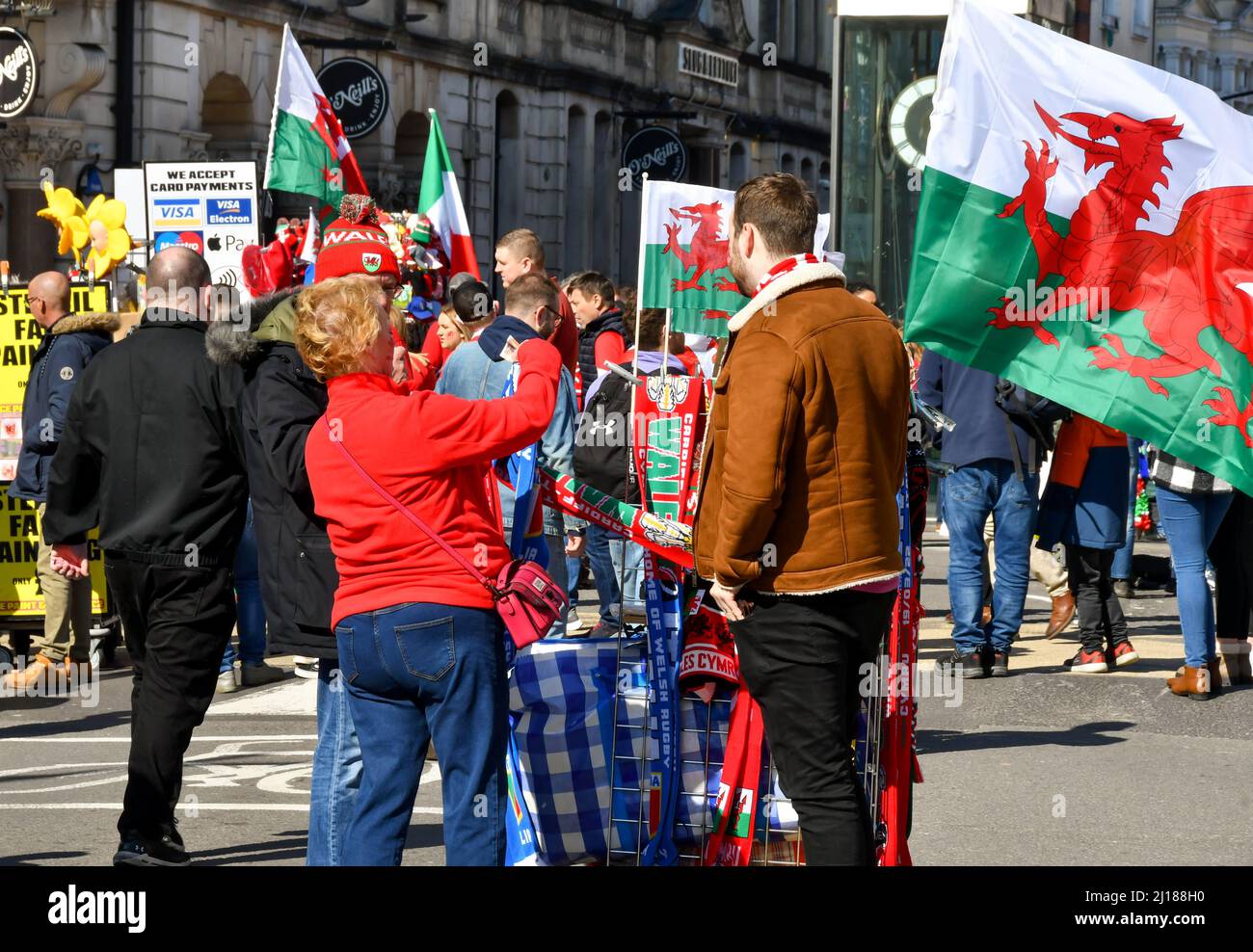 Cardiff, Galles - Marzo 2022: Fan di Rugby che acquistano souvenir da un commerciante di strada nel centro di Cardiff il giorno della partita Foto Stock