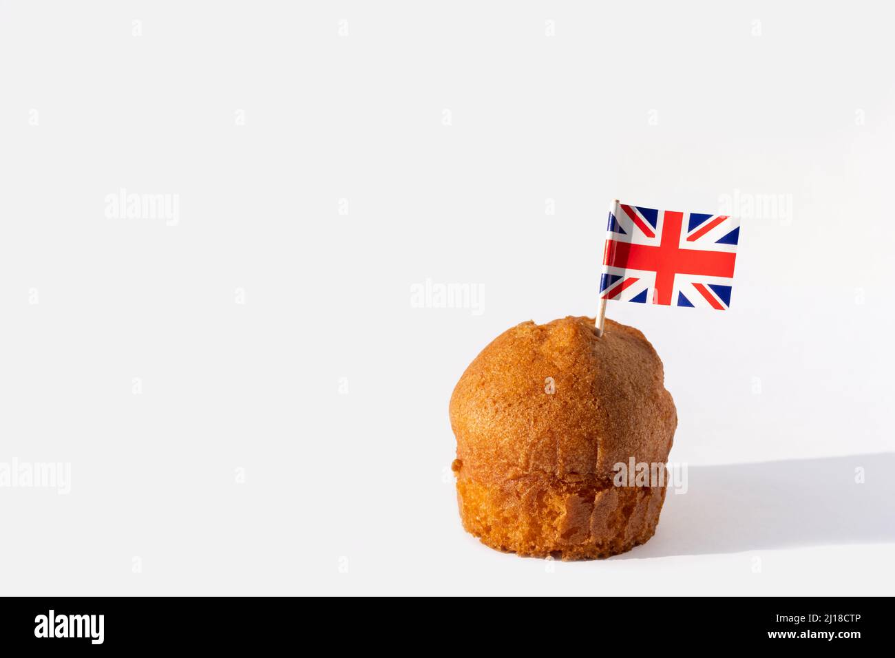 Cupcake fatto in casa con bandiera inglese su sfondo bianco, spazio copia. Giornata nazionale del Regno Unito. Il 12th aprile è il giorno della bandiera del Regno Unito. Foto Stock