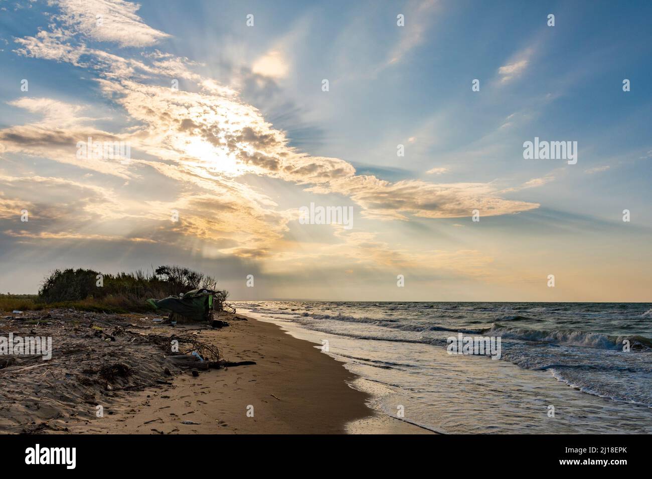 La decadenza del mare con la lettiera abbandonata sulla spiaggia Foto Stock