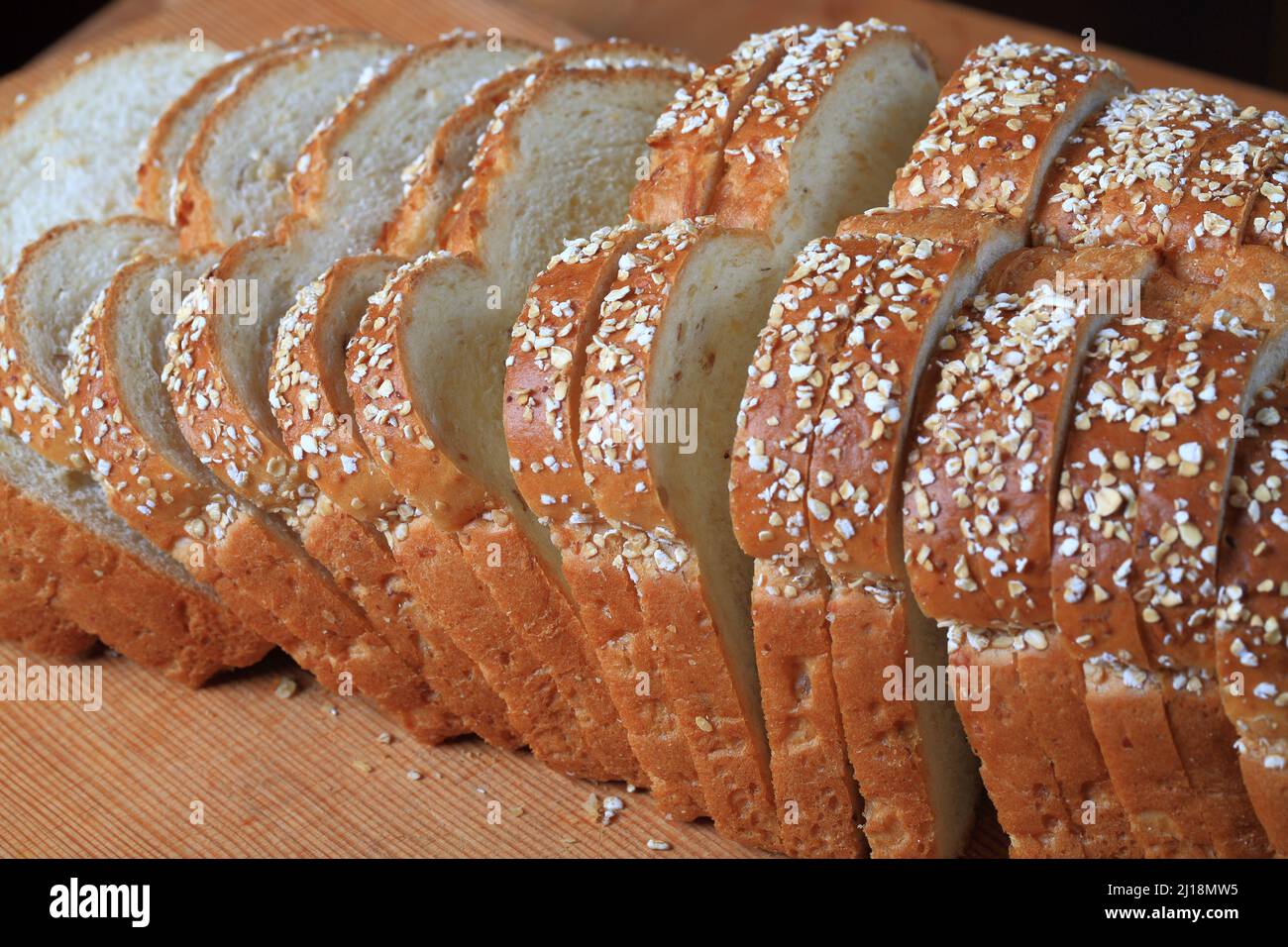 Pane affettato di farina d'avena su sfondo di legno Foto Stock