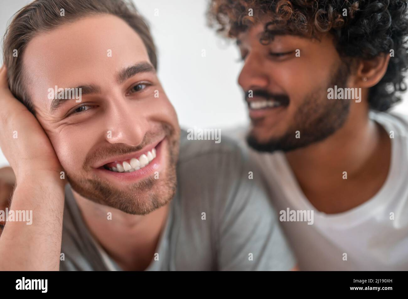 Ragazzo con capelli ricci che guarda il suo bel ragazzo Foto Stock