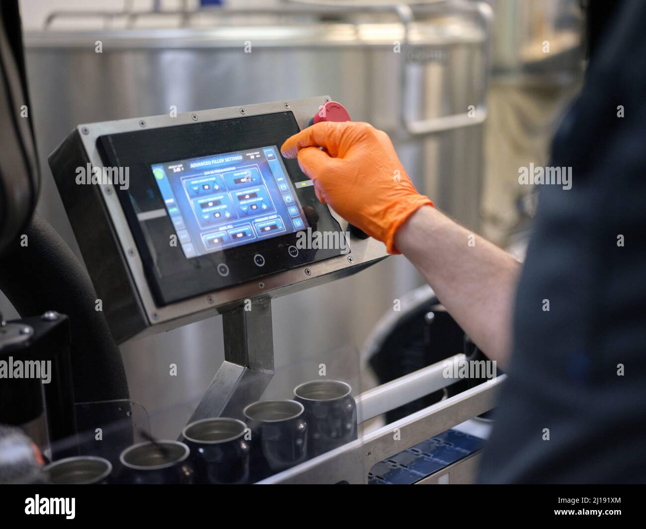 Operatore che utilizza una macchina per il riempimento elettronico della  birra in un birrificio Foto stock - Alamy