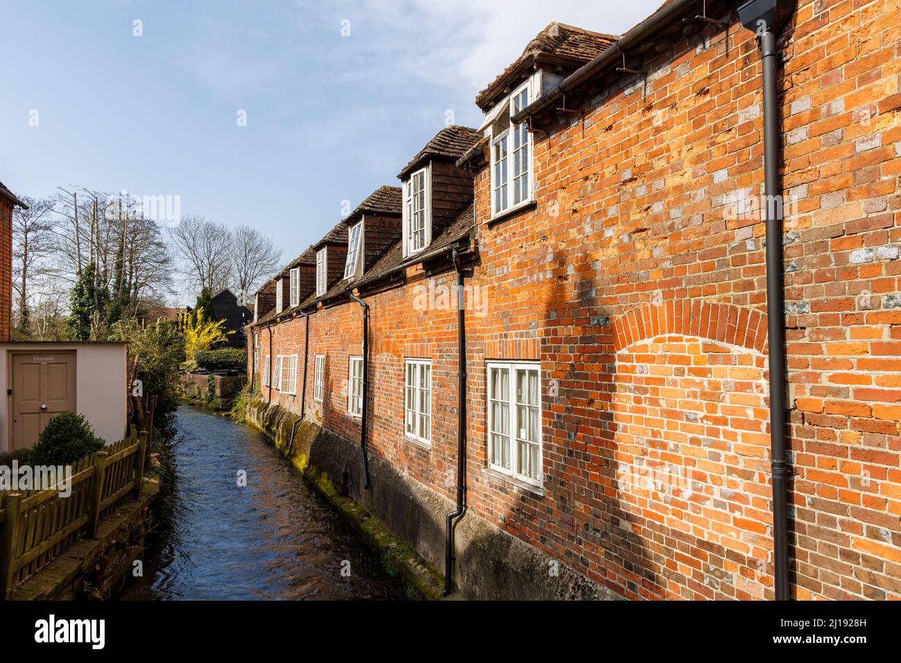 Case storiche in mattoni rossi con dormitorio e infilled finestre che si affacciano sul fiume Dun a Hungerford, una città nel Berkshire, Inghilterra Foto Stock