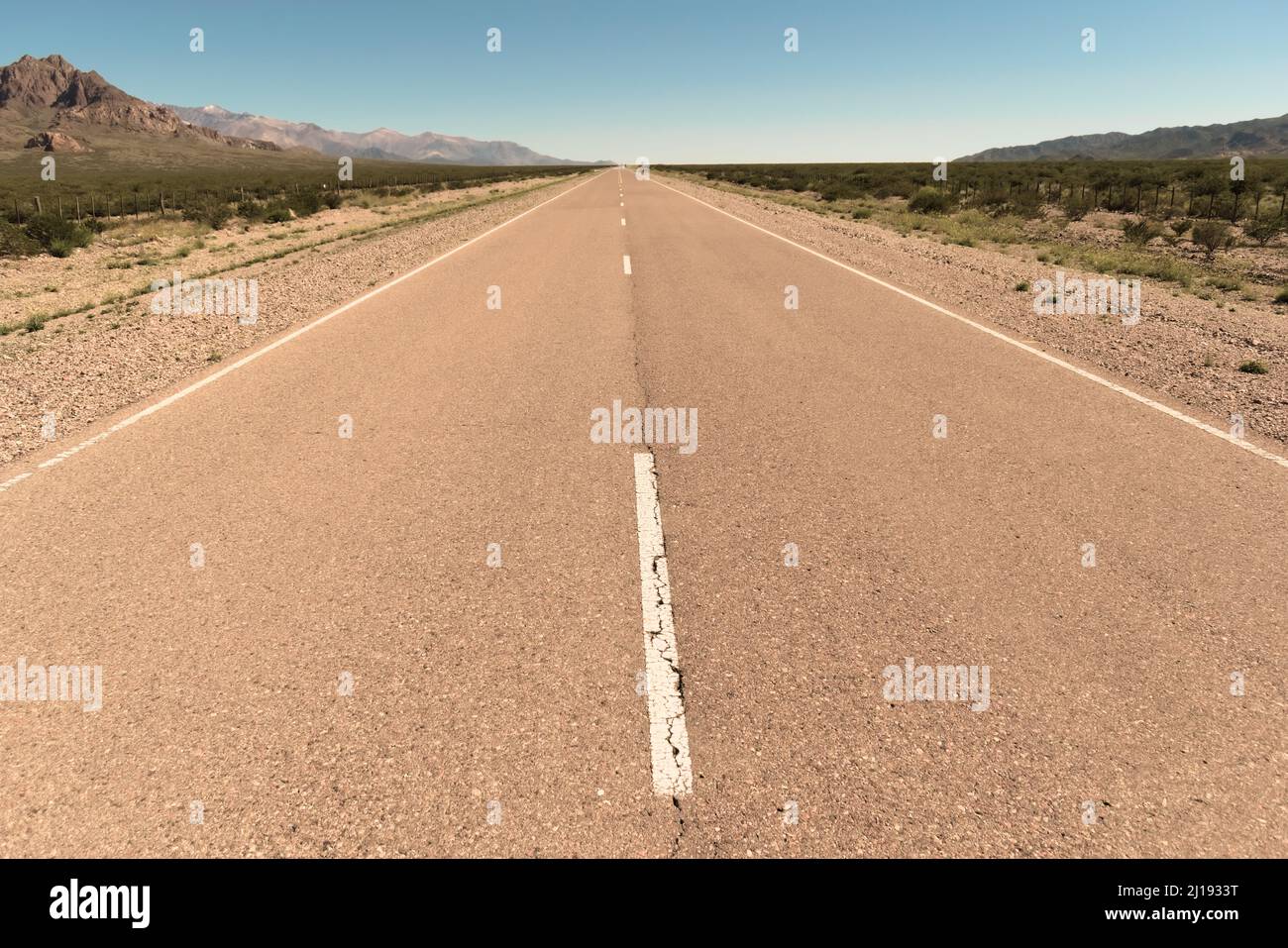 La strada asfaltata svanisce in lontananza nel deserto di San Juan, Argentina. Foto Stock