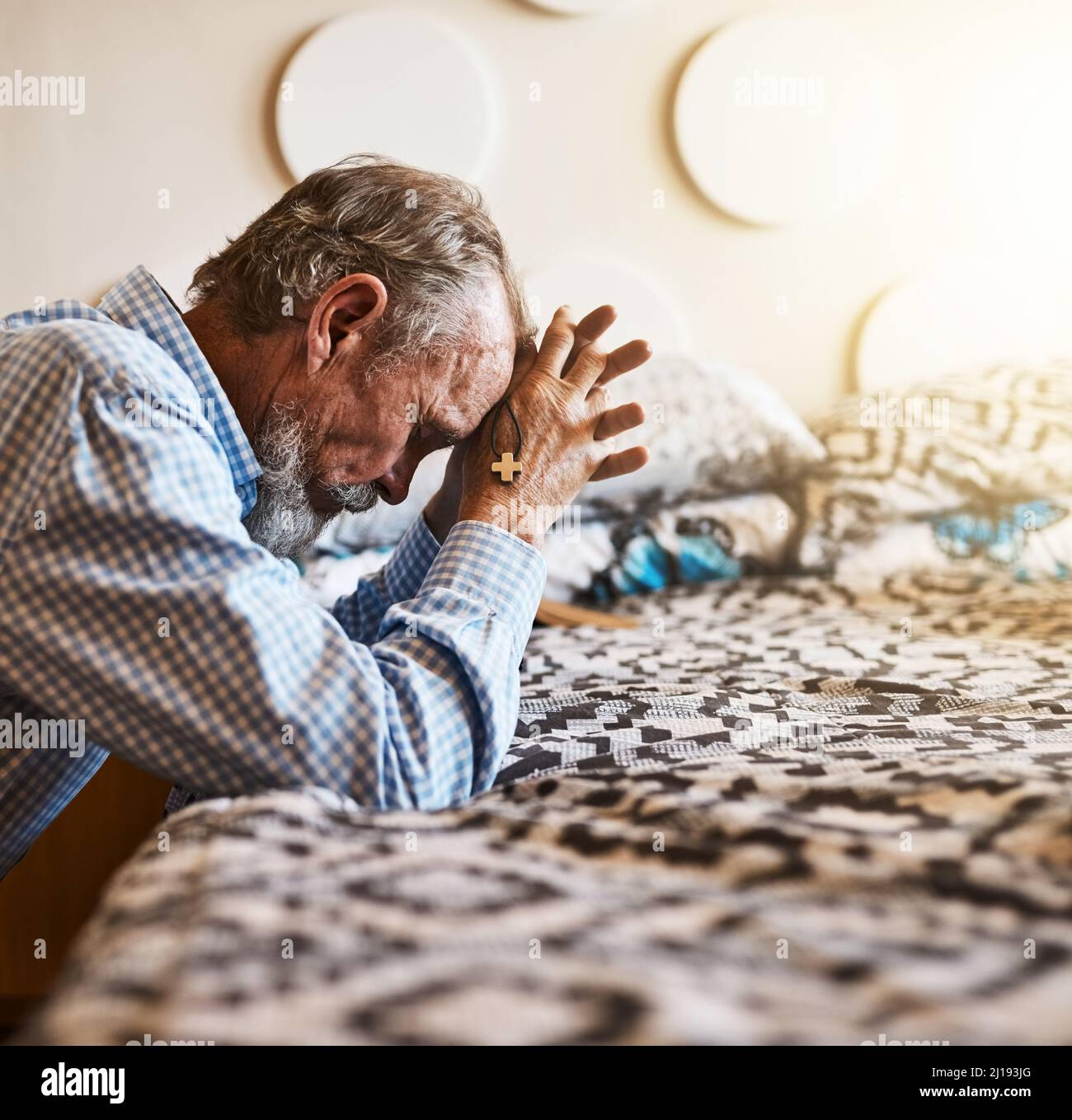 Un po' di tempo da solo per dire Grazie di tutto. Colpo di un uomo anziano tranquillo inginocchiato accanto al suo letto e pregando con gli occhi chiusi. Foto Stock