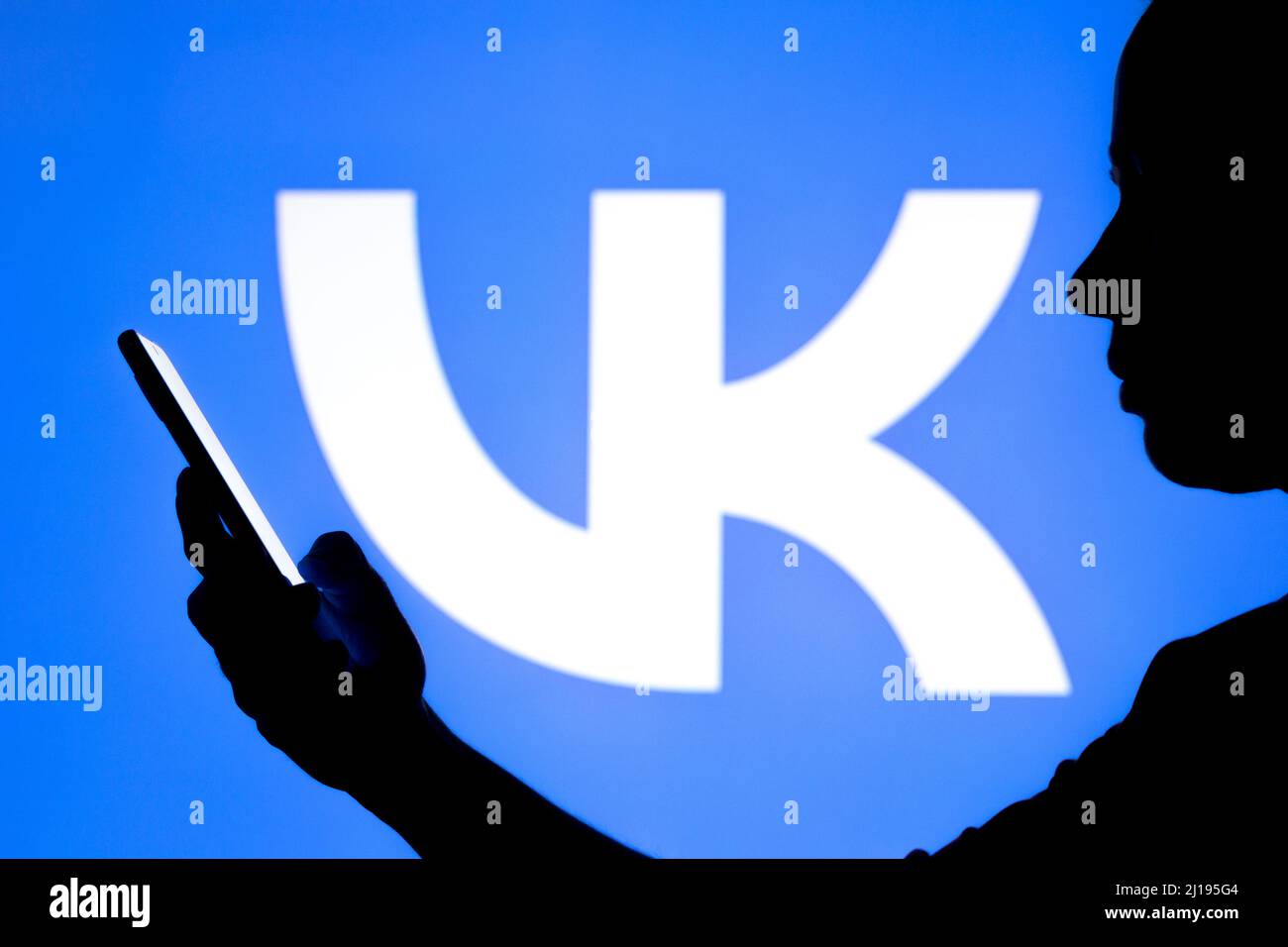 Brasile. 23rd Mar 2022. In questa foto, la silhouette di una donna contiene uno smartphone con il logo VKontakte (VK) sullo sfondo. Credit: SOPA Images Limited/Alamy Live News Foto Stock