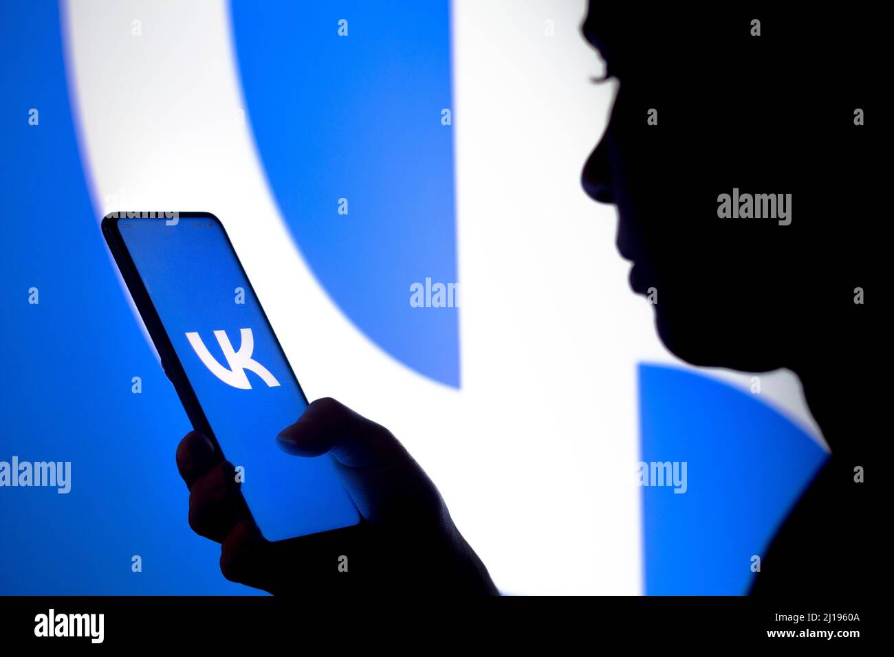 Brasile. 23rd Mar 2022. In questa foto, la silhouette di una donna contiene uno smartphone con il logo VKontakte (VK) visualizzato sullo schermo e sullo sfondo. (Foto di Rafael Henrique/SOPA Images/Sipa USA) Credit: Sipa USA/Alamy Live News Foto Stock