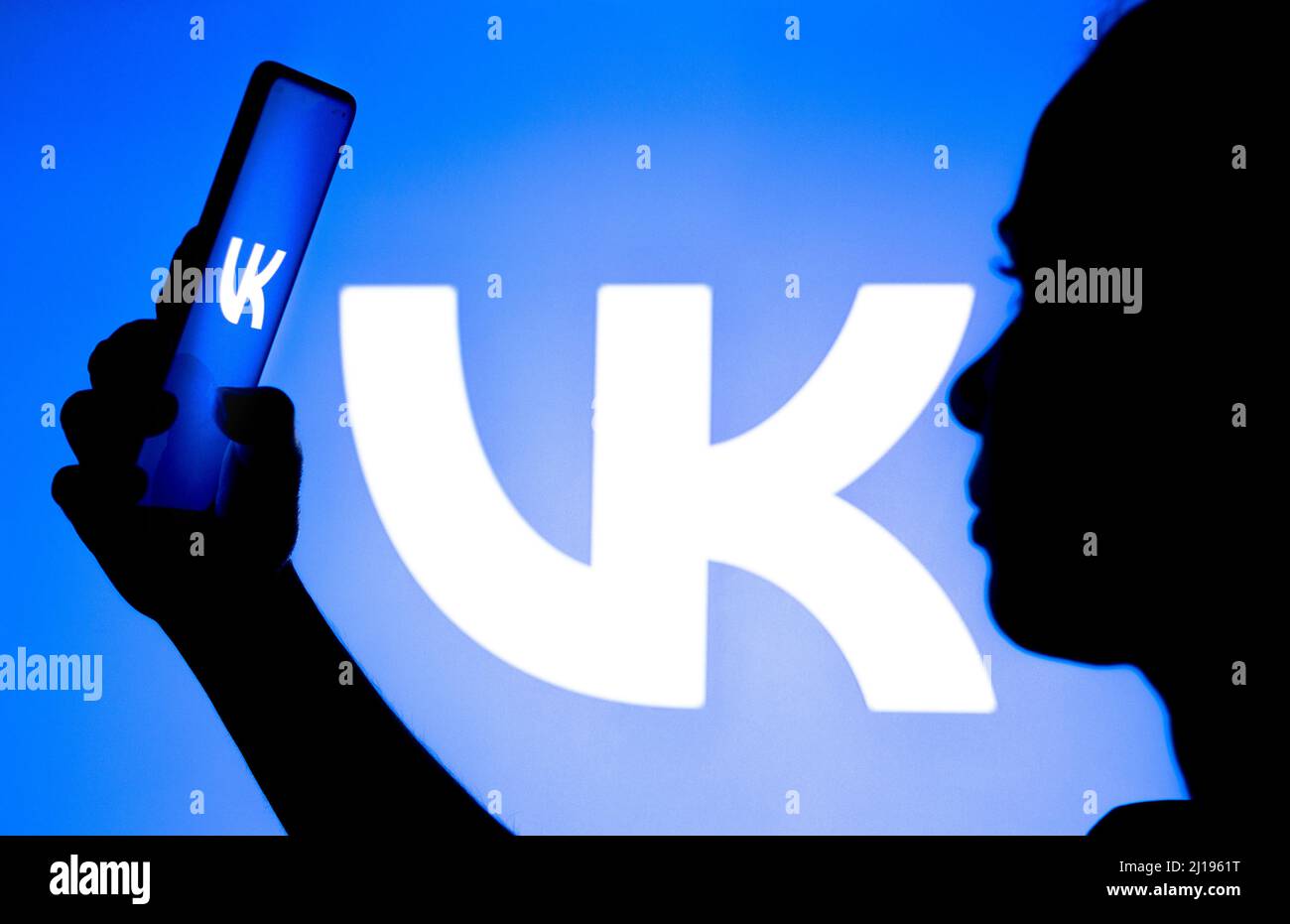 Brasile. 23rd Mar 2022. In questa foto, la silhouette di una donna contiene uno smartphone con il logo VKontakte (VK) visualizzato sullo schermo e sullo sfondo. (Foto di Rafael Henrique/SOPA Images/Sipa USA) Credit: Sipa USA/Alamy Live News Foto Stock