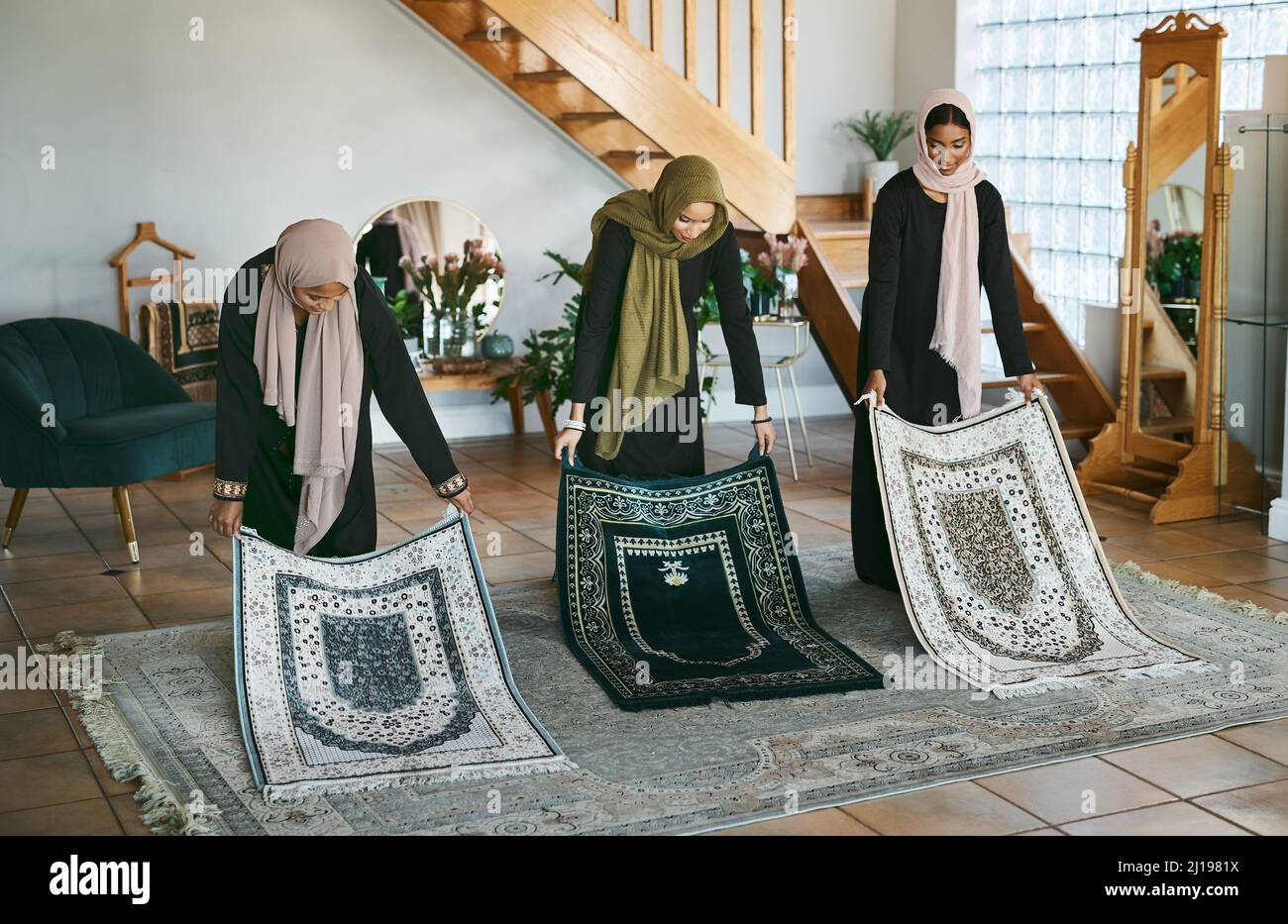 La preparazione è importante. Shot di un gruppo di donne musulmane che posano i loro stuoie di preghiera in preparazione. Foto Stock