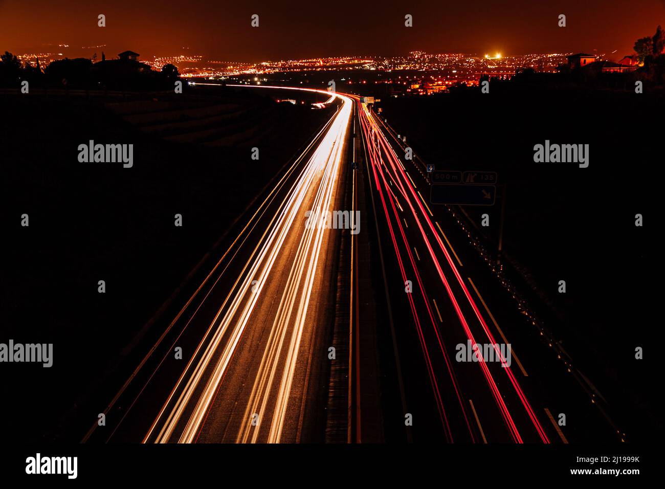 percorsi auto su una strada al crepuscolo. Foto Stock