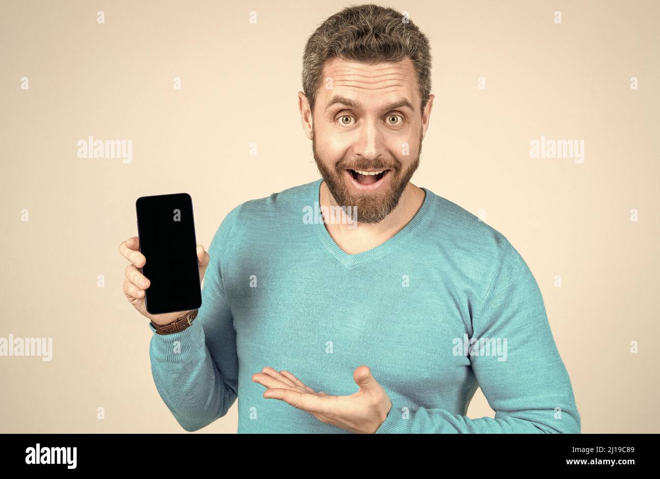 uomo felice con la barba che dimostra smartphone, promozione Foto Stock