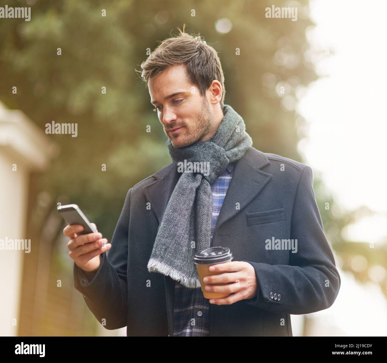 Resta sempre al corrente quando sei in viaggio. Scatto di un giovane che usa il suo telefono all'esterno. Foto Stock
