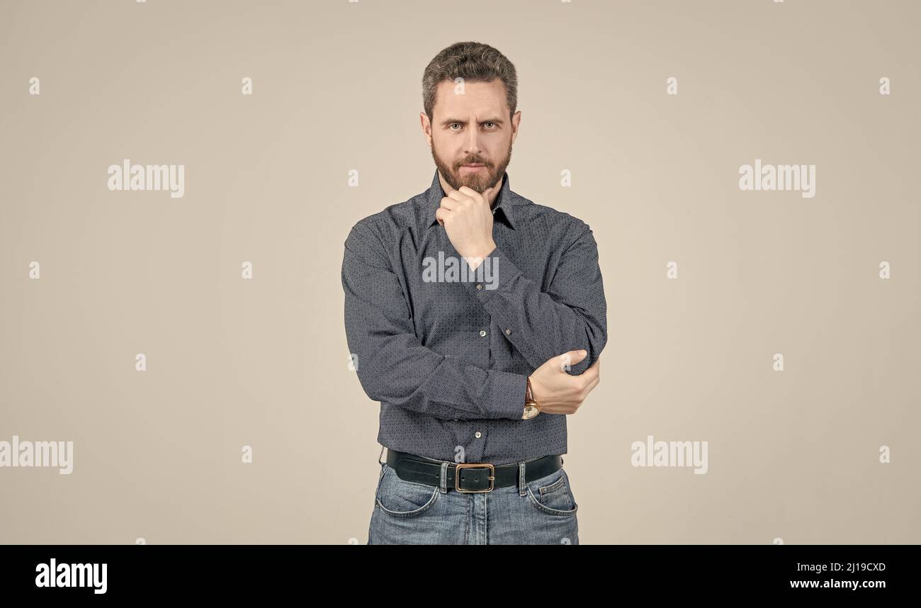 Abbigliamento per l'uomo serio. L'uomo bearded pensa sfondo grigio. Aspetto serio. Mento proppante Foto Stock
