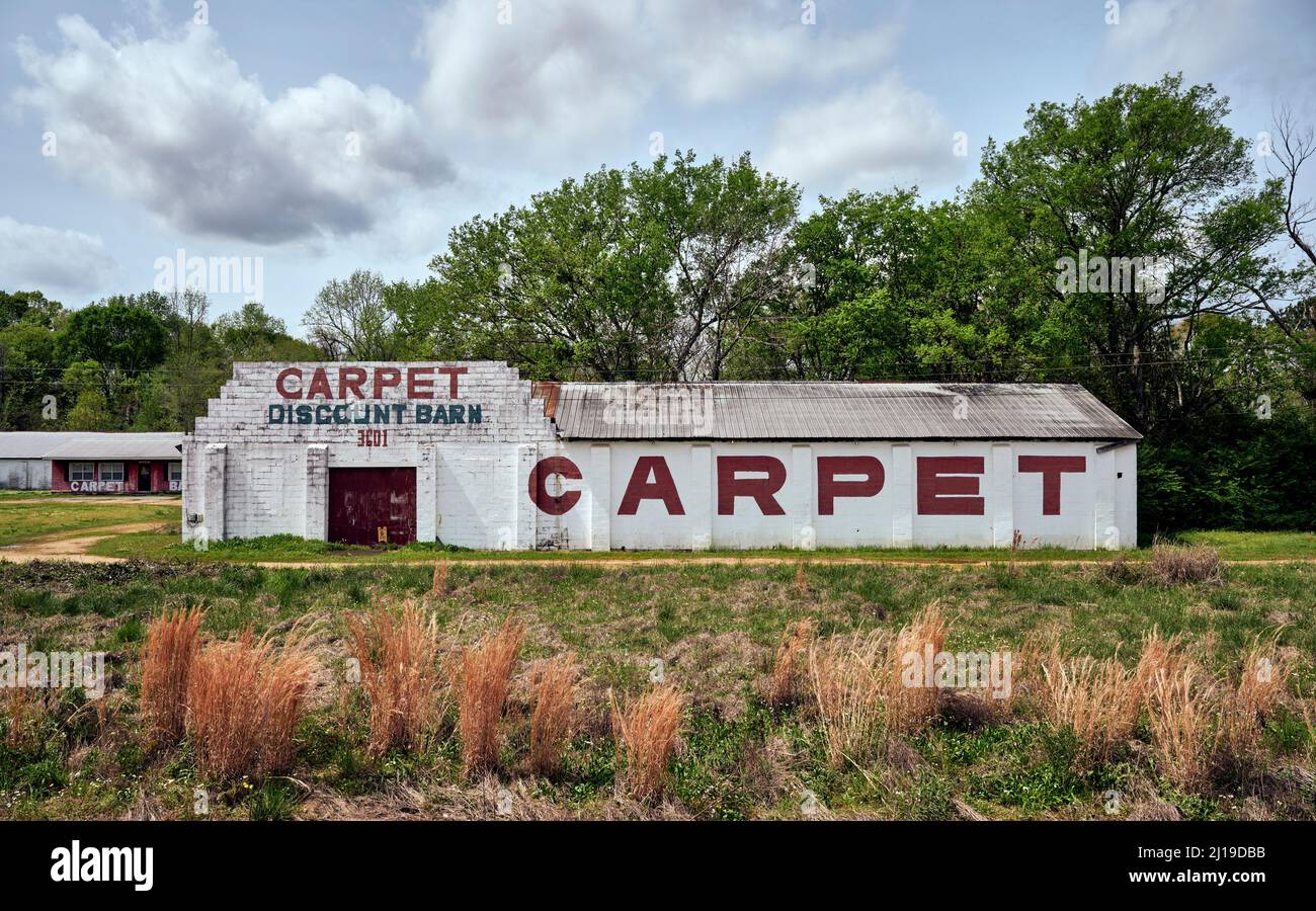 Sconto Carpet Barn edificio con un grande cartello dipinto sul lato dell'edificio, a Montgomery Alabama, USA. Foto Stock