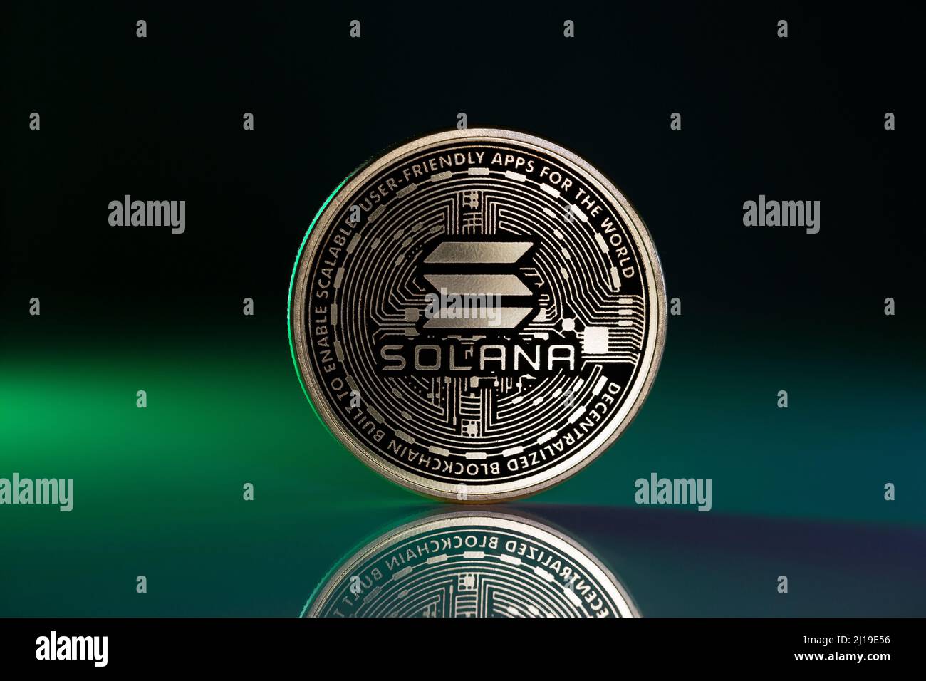 Solana Sol Coin fisico posto su superficie riflettente e illuminato con luce  verde Foto stock - Alamy